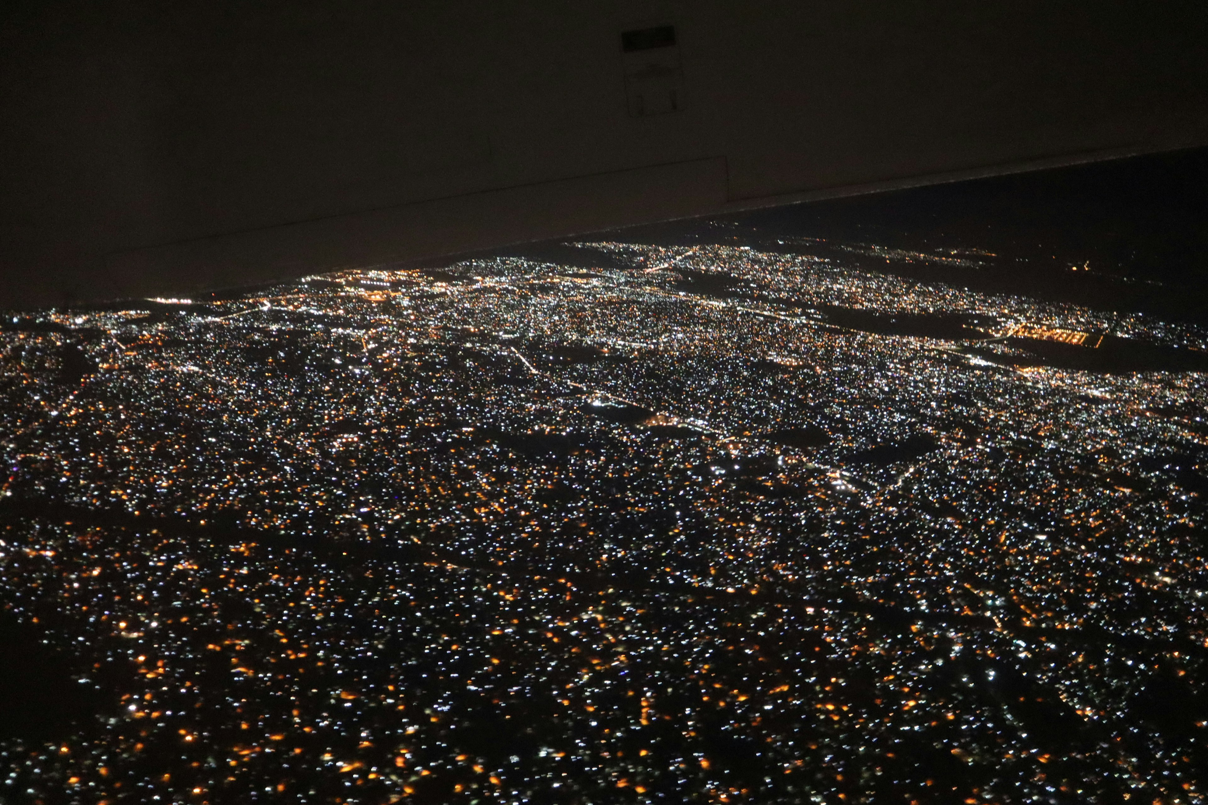 Aerial view of a city at night illuminated by city lights and buildings