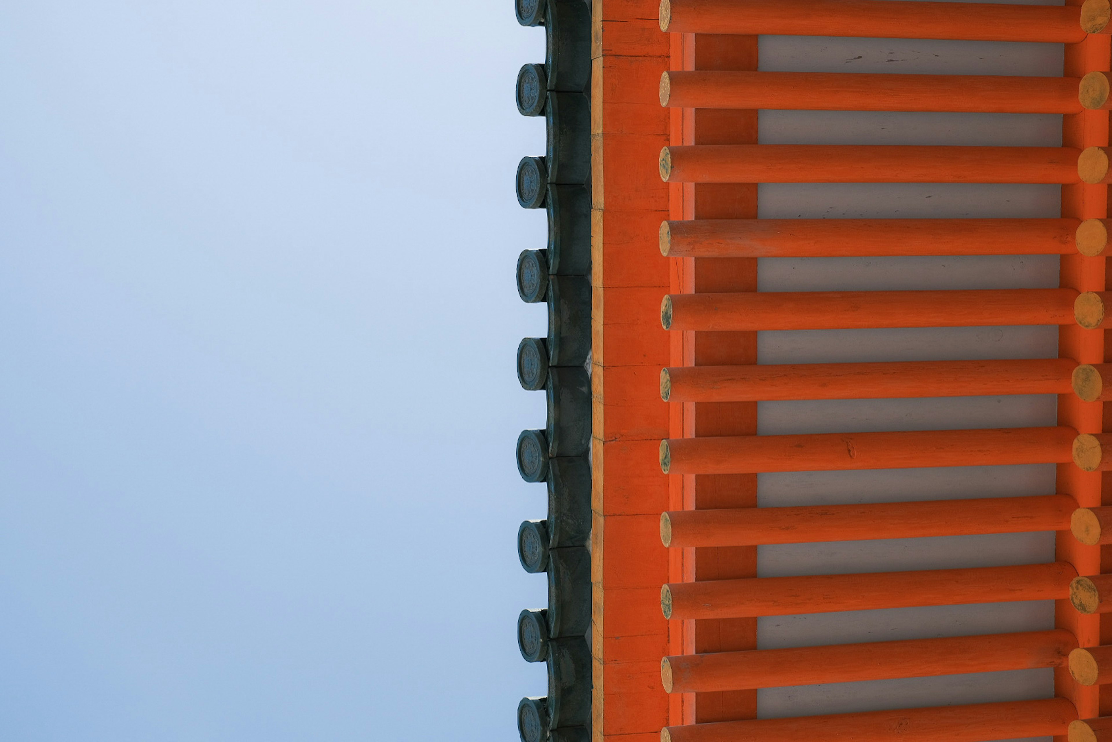 Part of an orange roof under a blue sky