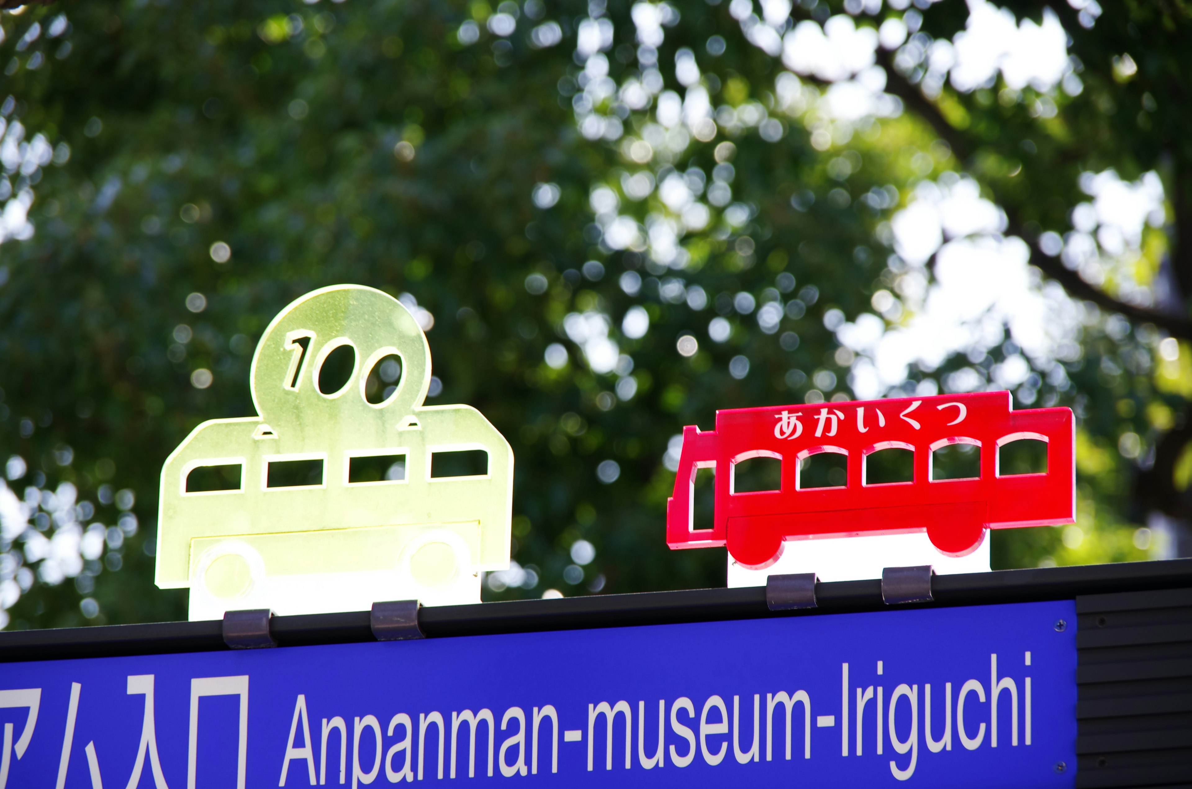 Panneau avec des bus et des trains de dessin animé pour l'entrée du musée Anpanman