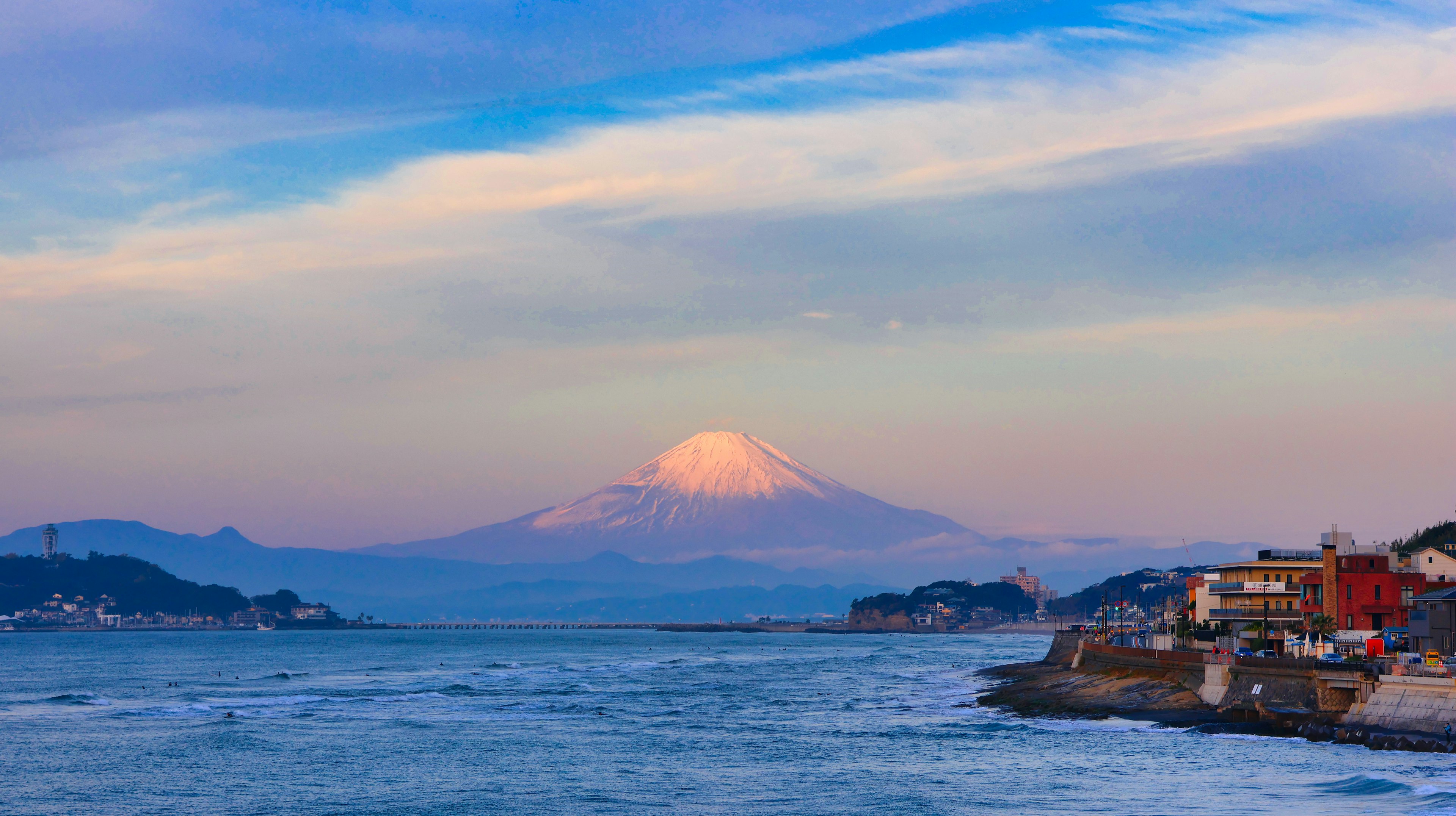 ทิวทัศน์ที่สวยงามของภูเขาฟูจิในยามพระอาทิตย์ตกพร้อมกับมหาสมุทรและเมือง