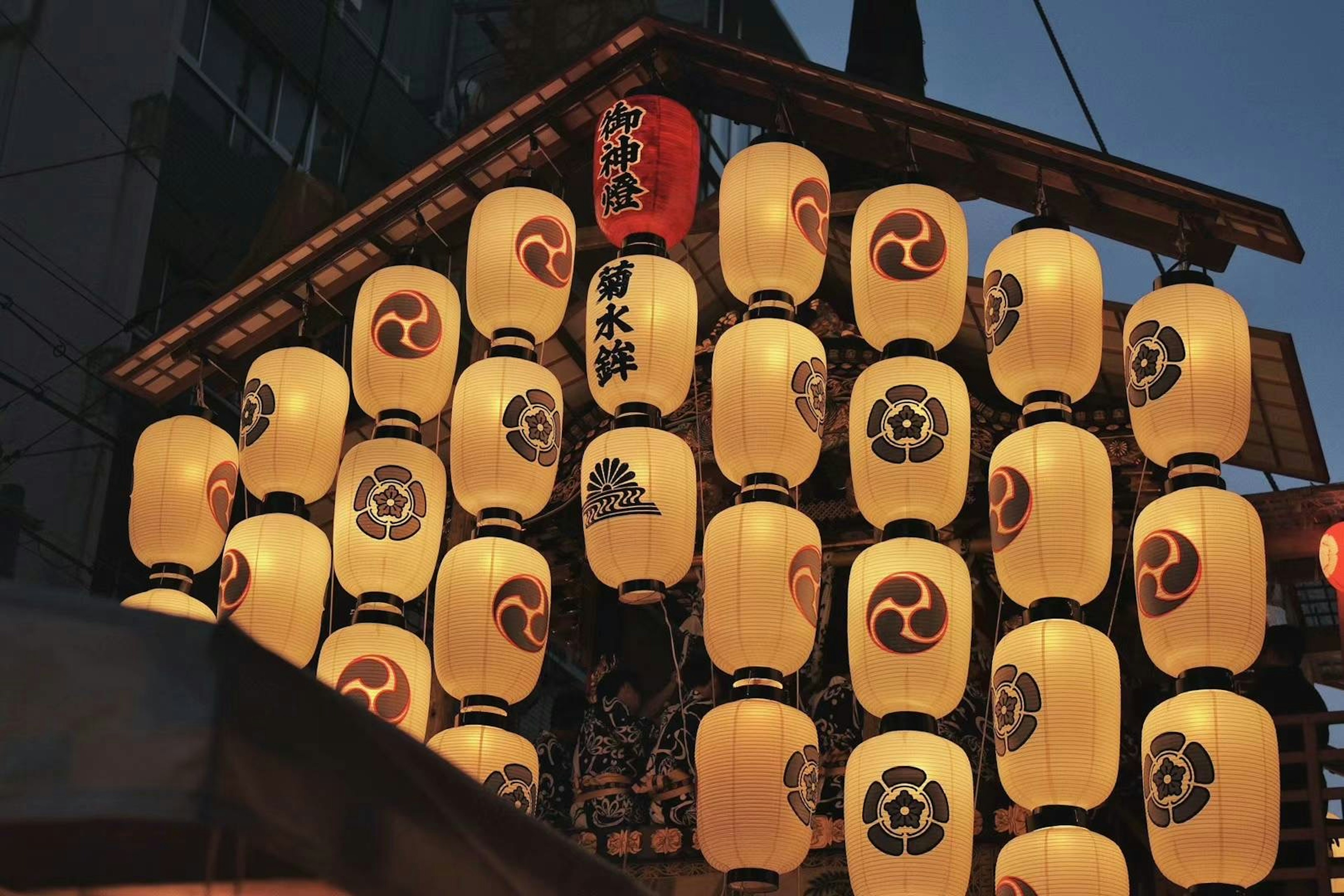 Traditional Japanese lanterns hanging in a row under the night sky