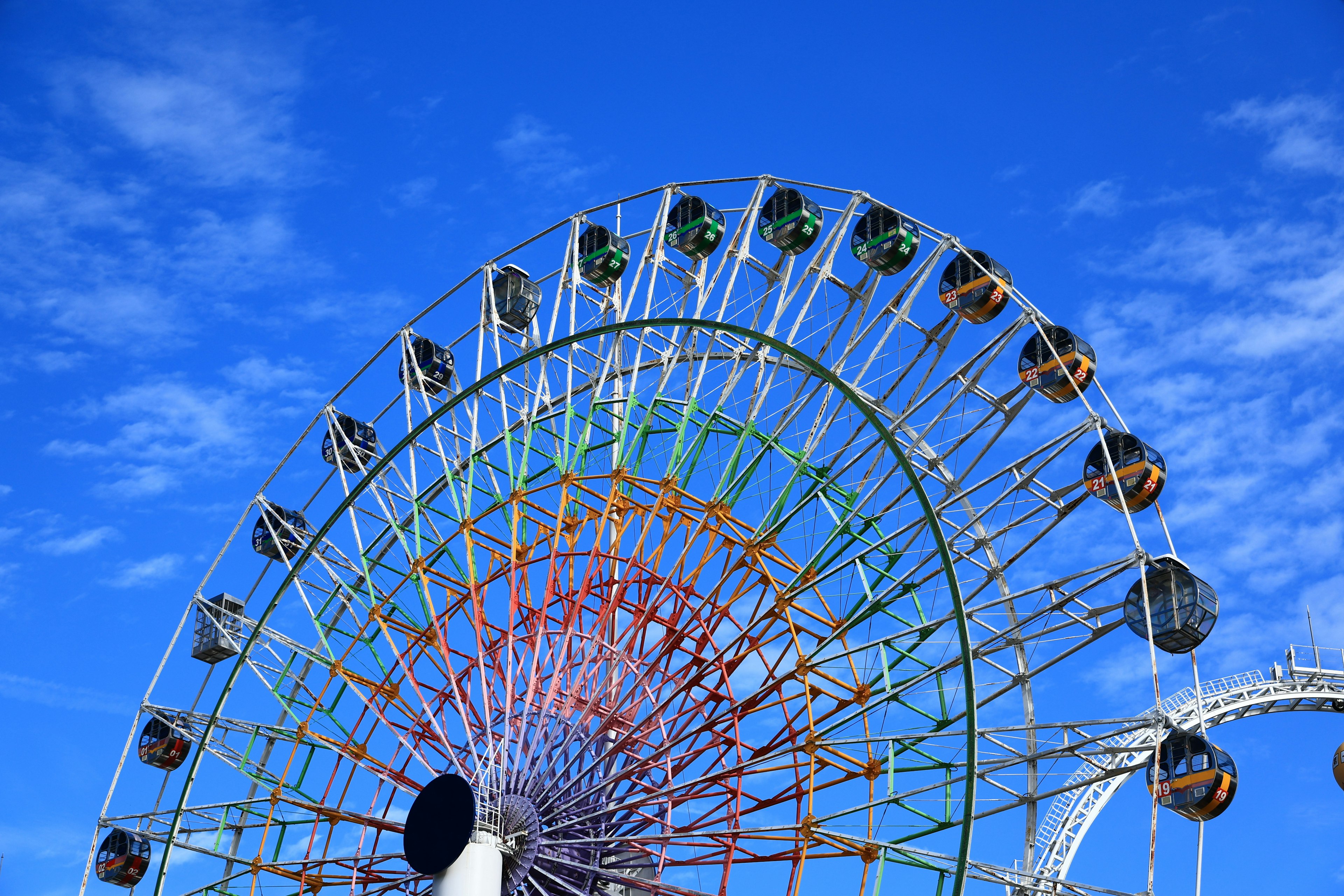 Close-up of a large Ferris wheel against a bright blue sky