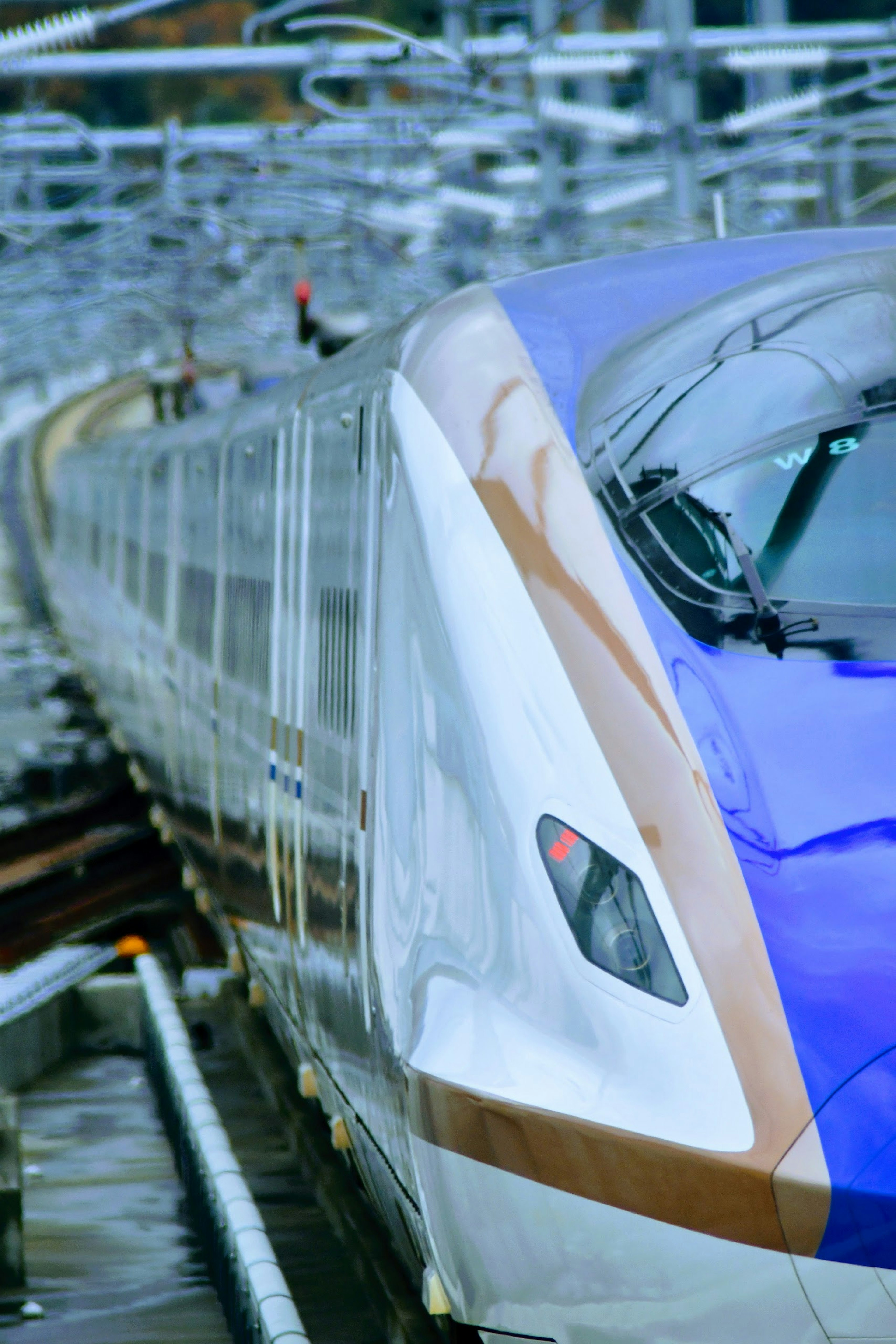 Primer plano de un tren Shinkansen azul y blanco