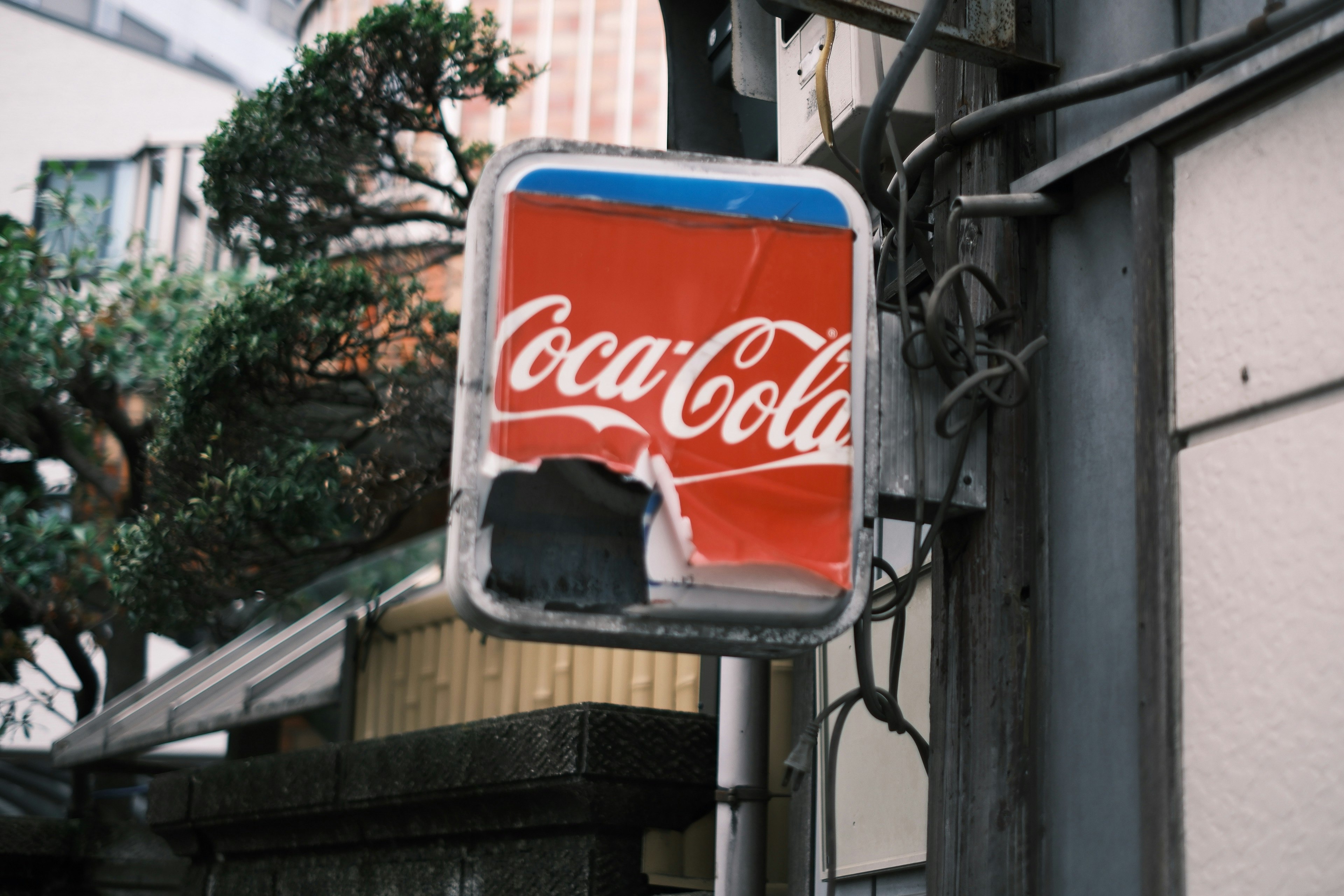 Cartel de Coca-Cola desgastado montado en una pared