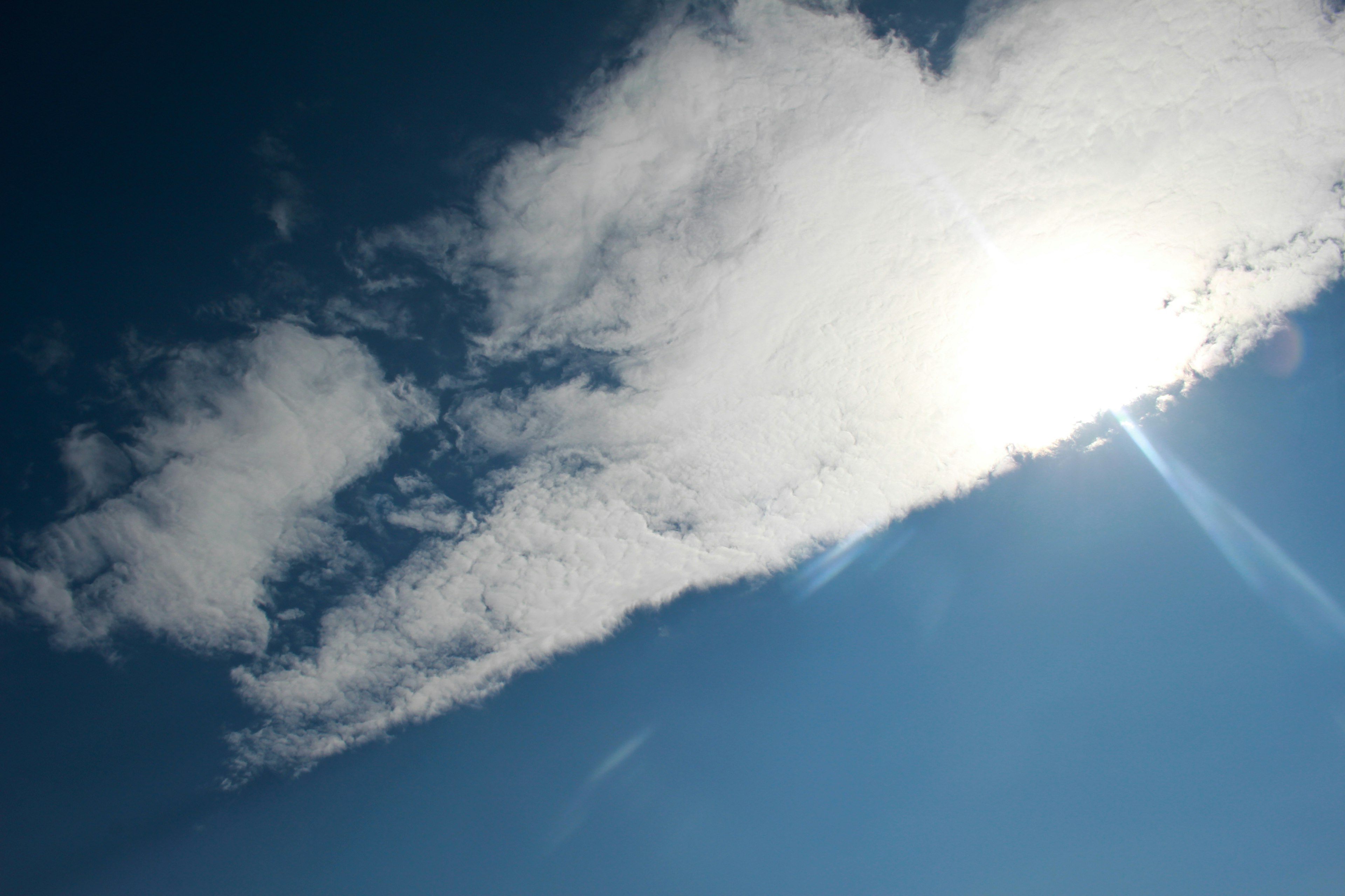 Awan yang diterangi sinar matahari di langit biru