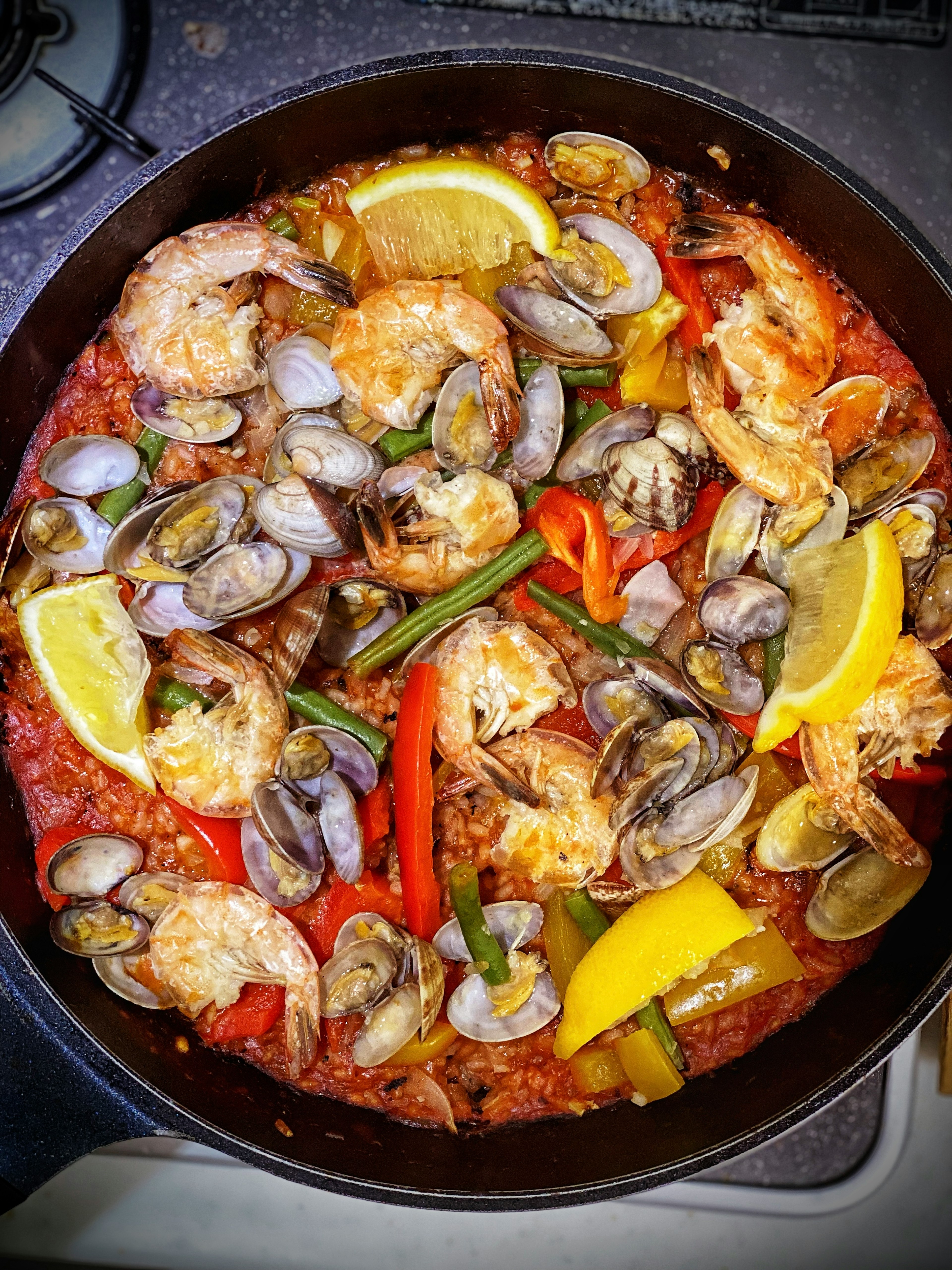 Seafood paella featuring shrimp and clams with colorful vegetables