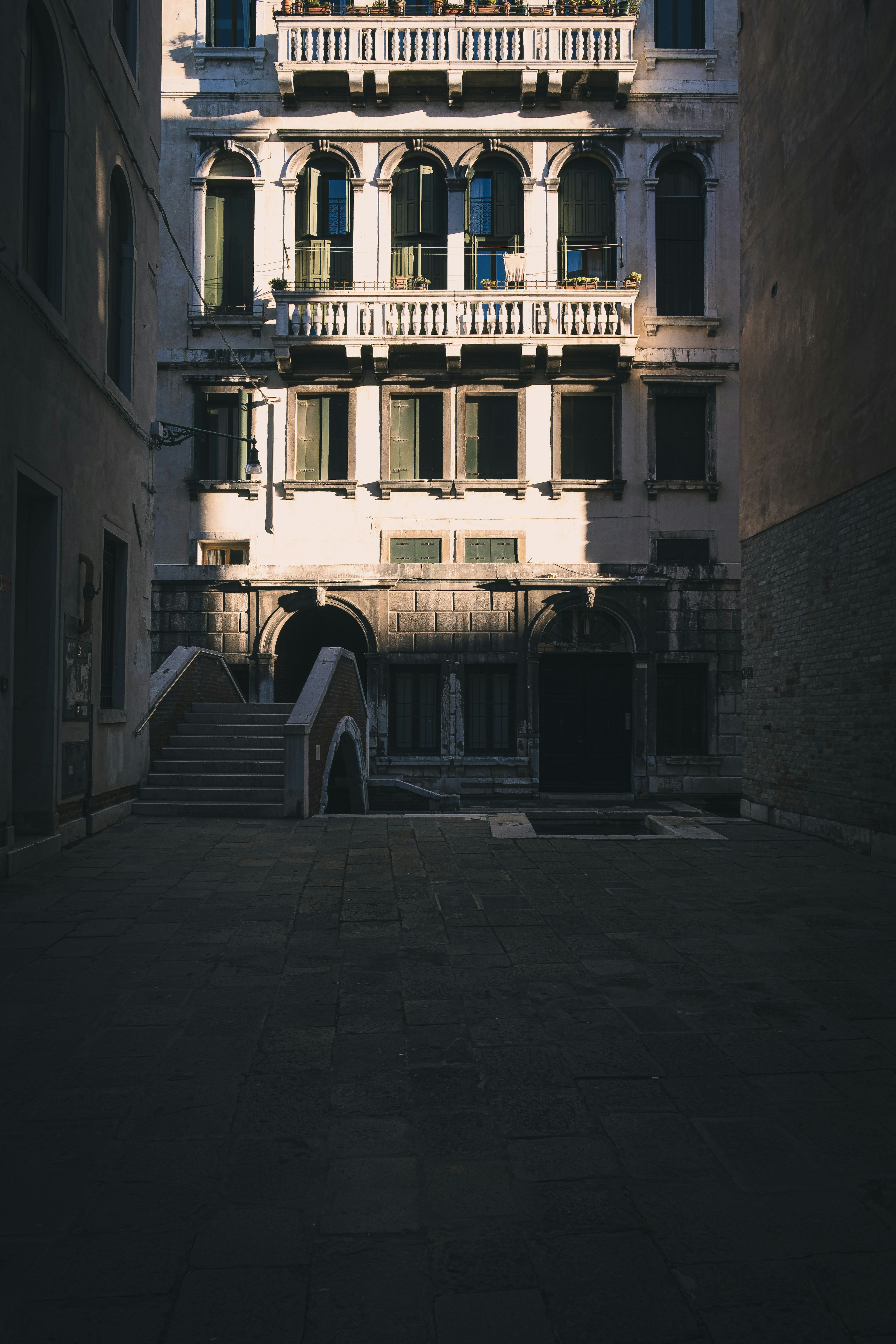 Beautiful Venetian building with shadows and cobblestone street