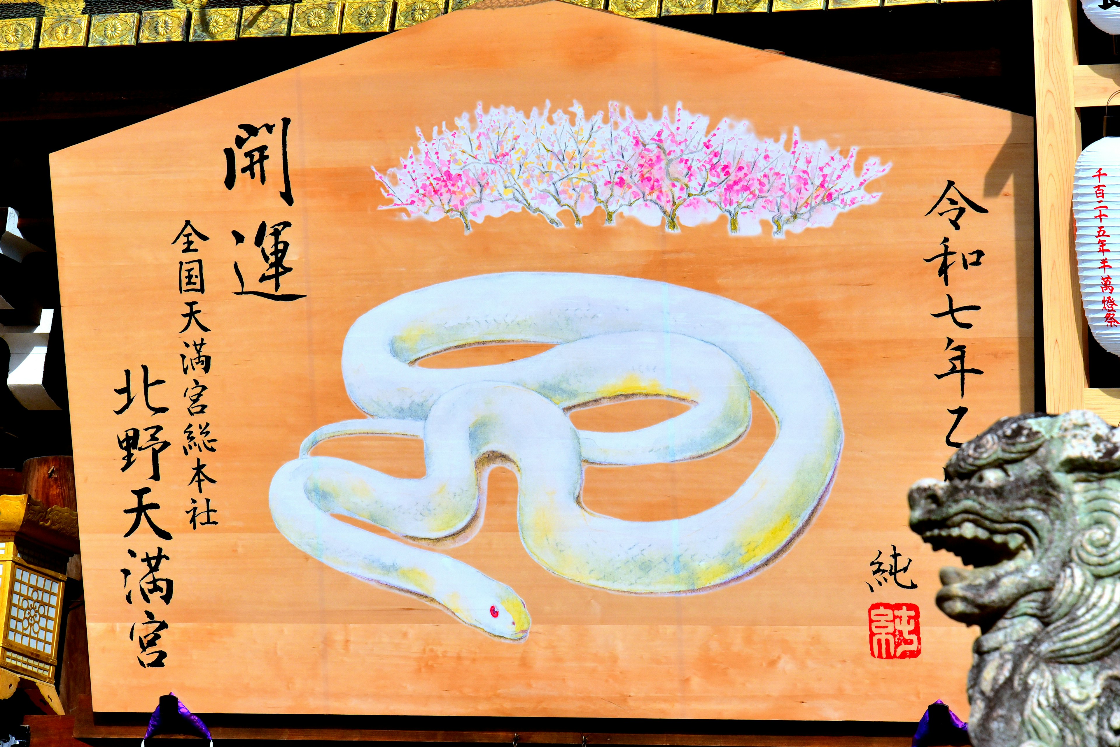 Wooden plaque featuring a white snake and floral decorations