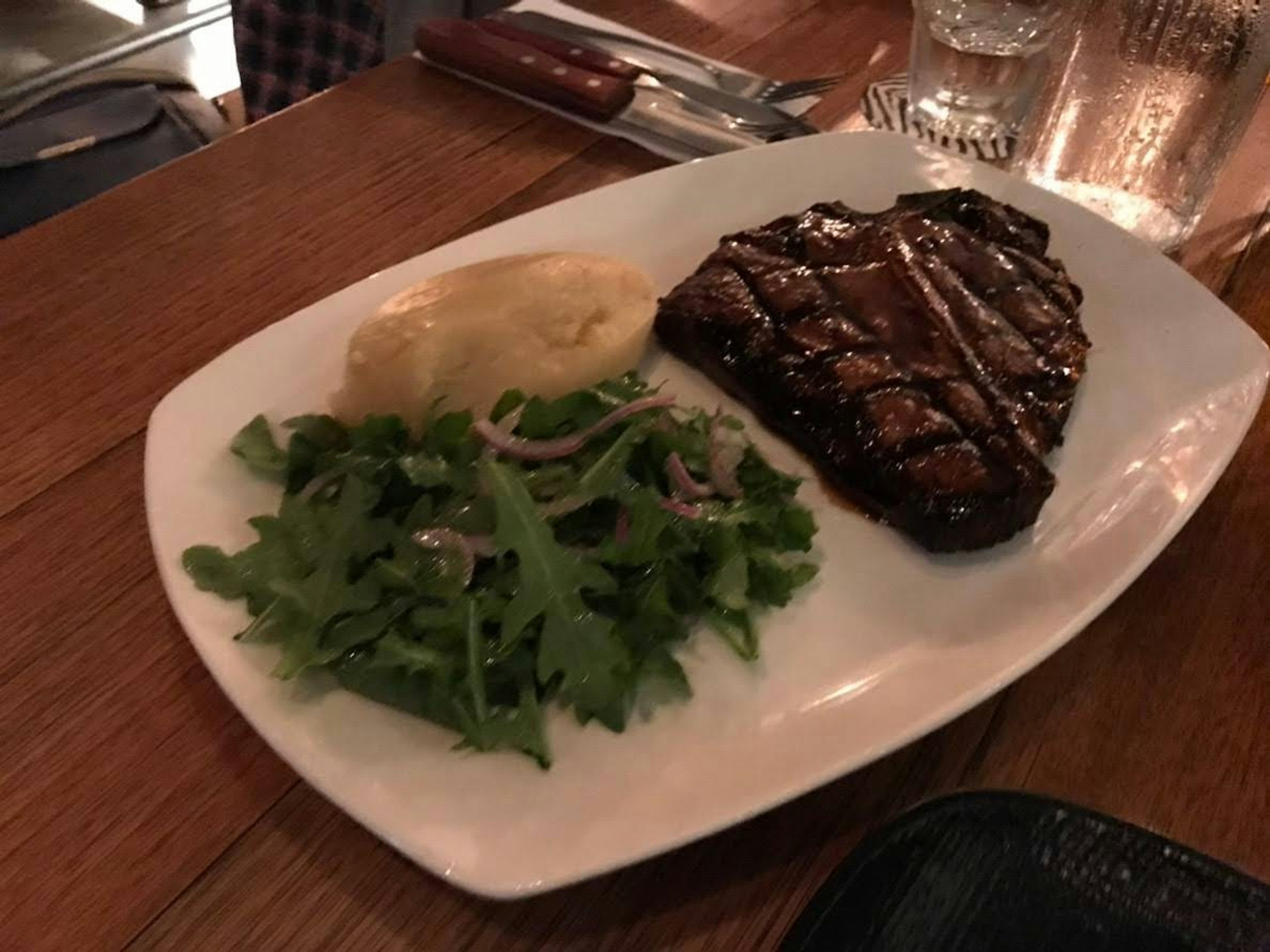 Steak grillé avec salade et purée de pommes de terre sur une assiette