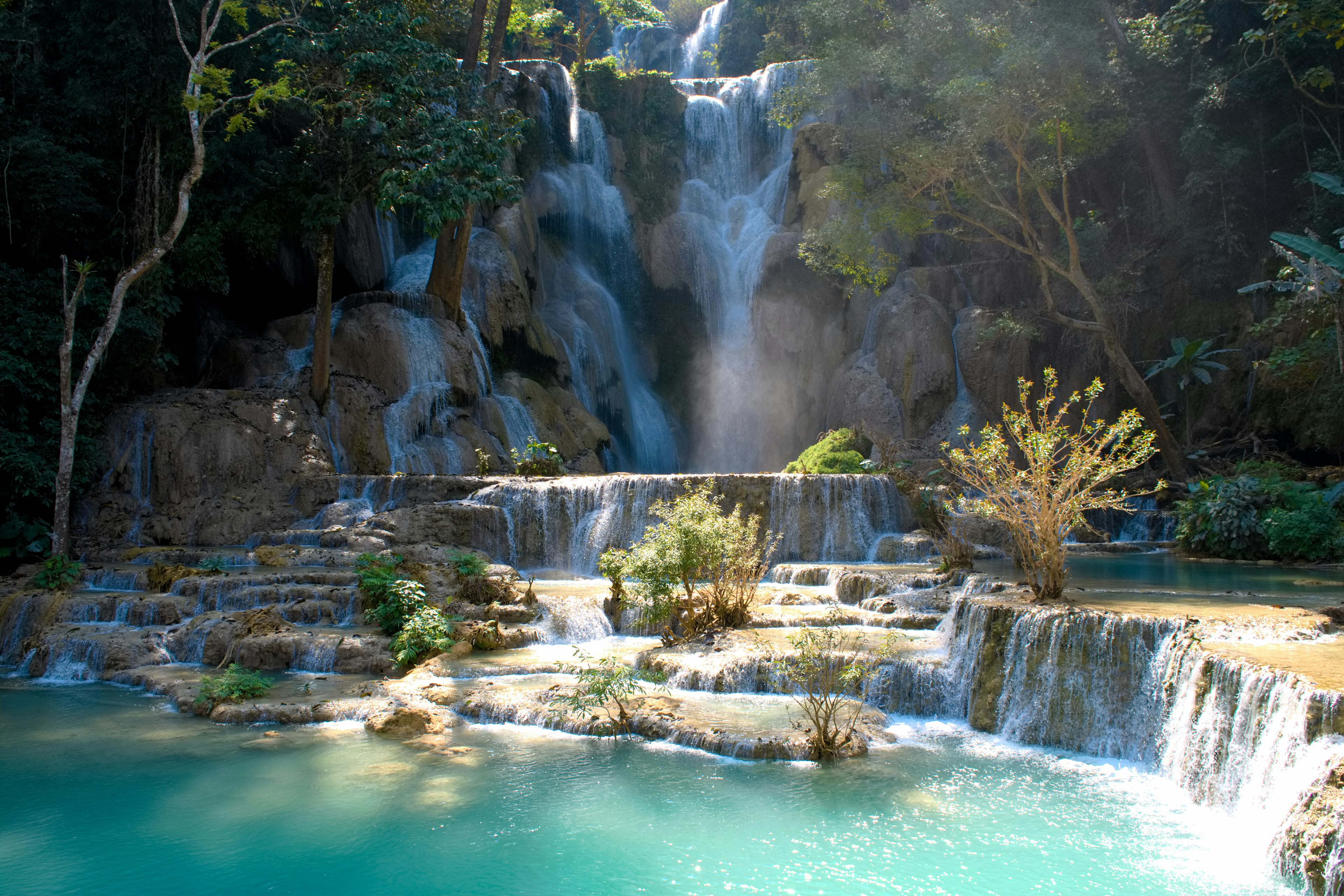 Hermosa cascada que cae en agua turquesa rodeada de vegetación exuberante