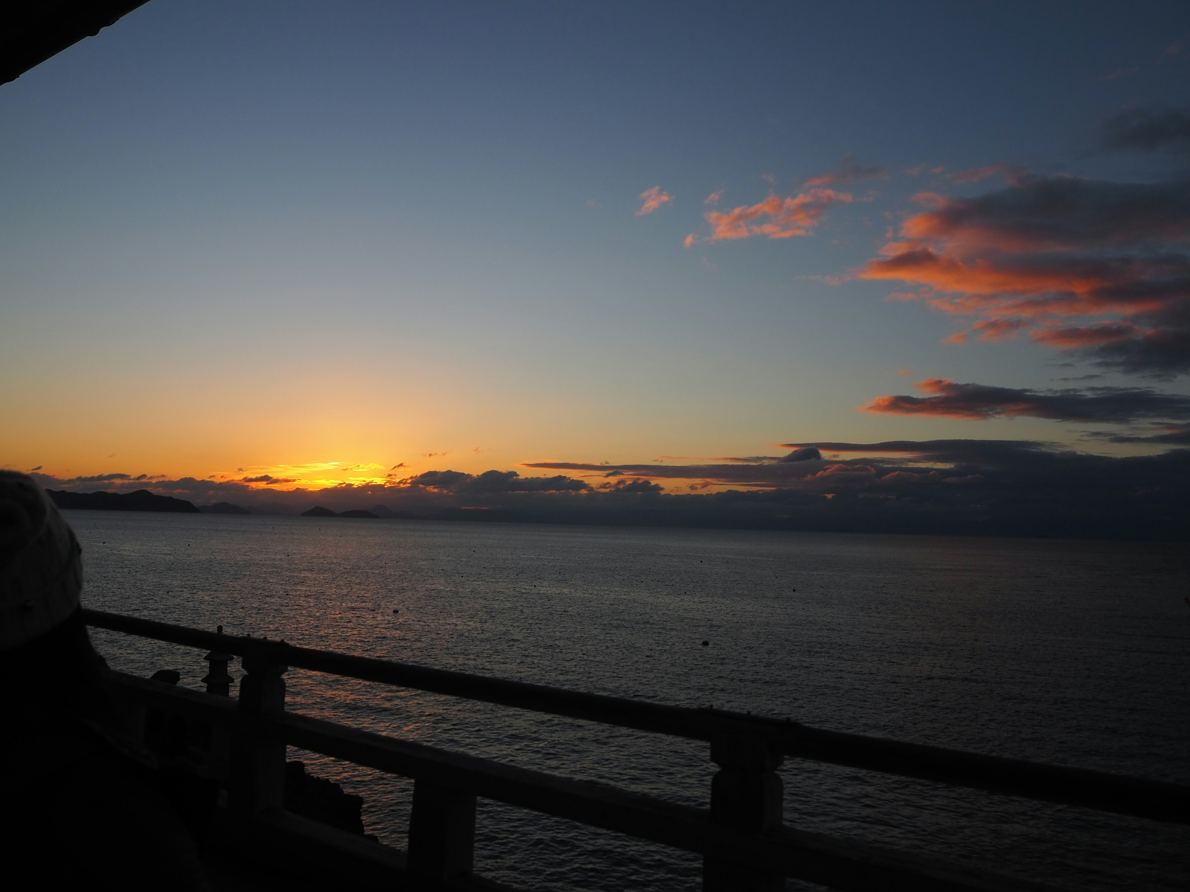 Sonnenuntergang über dem Ozean mit silhouettierten Wolken