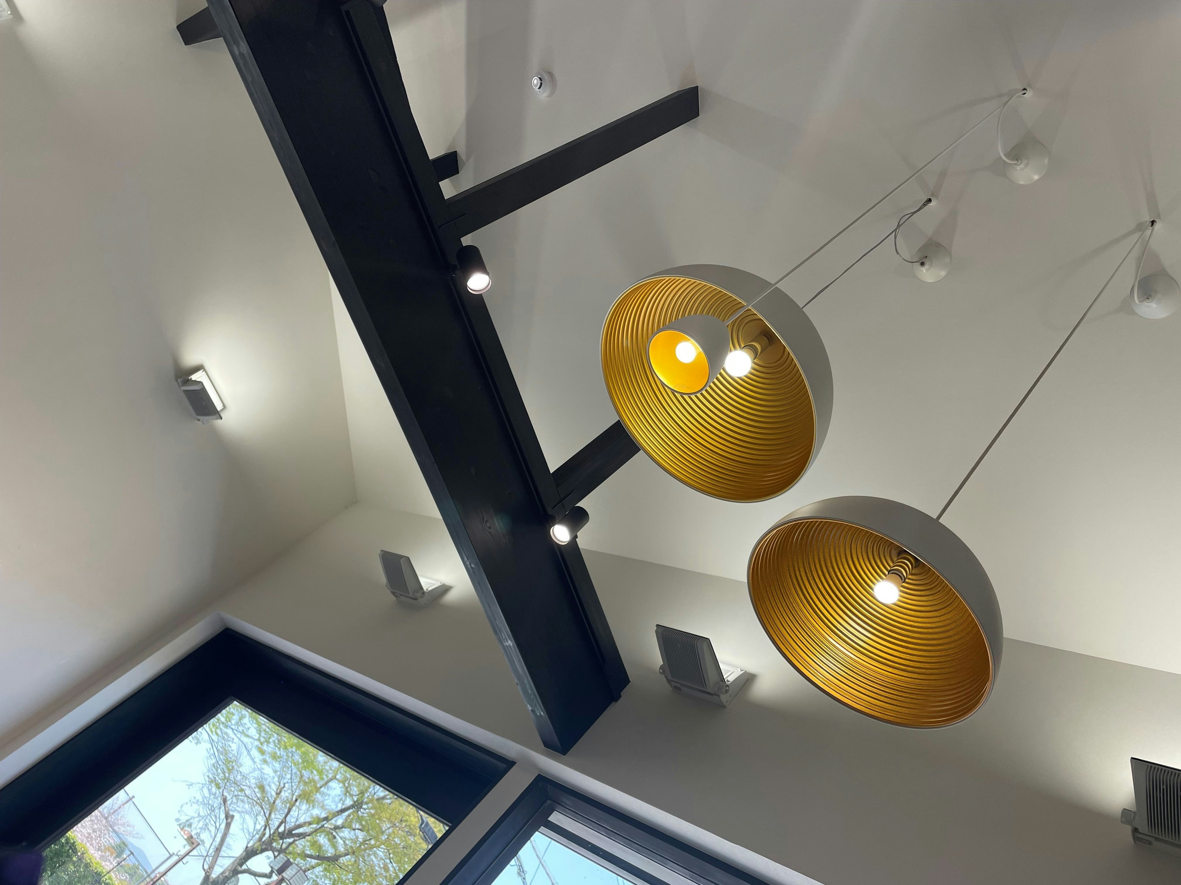 Ceiling with hanging golden light fixtures and black beam