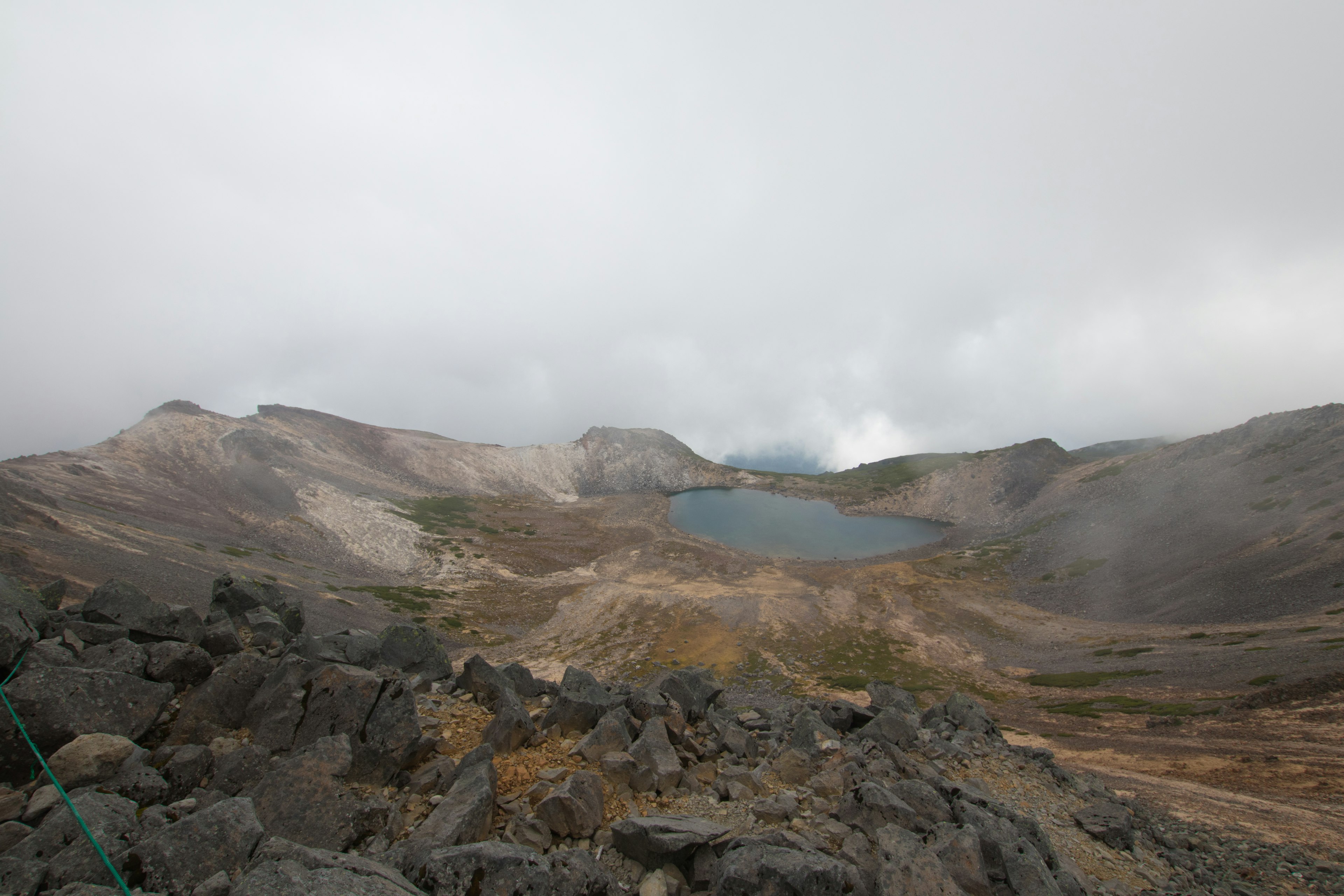 Un paesaggio montano nuvoloso con un lago visibile