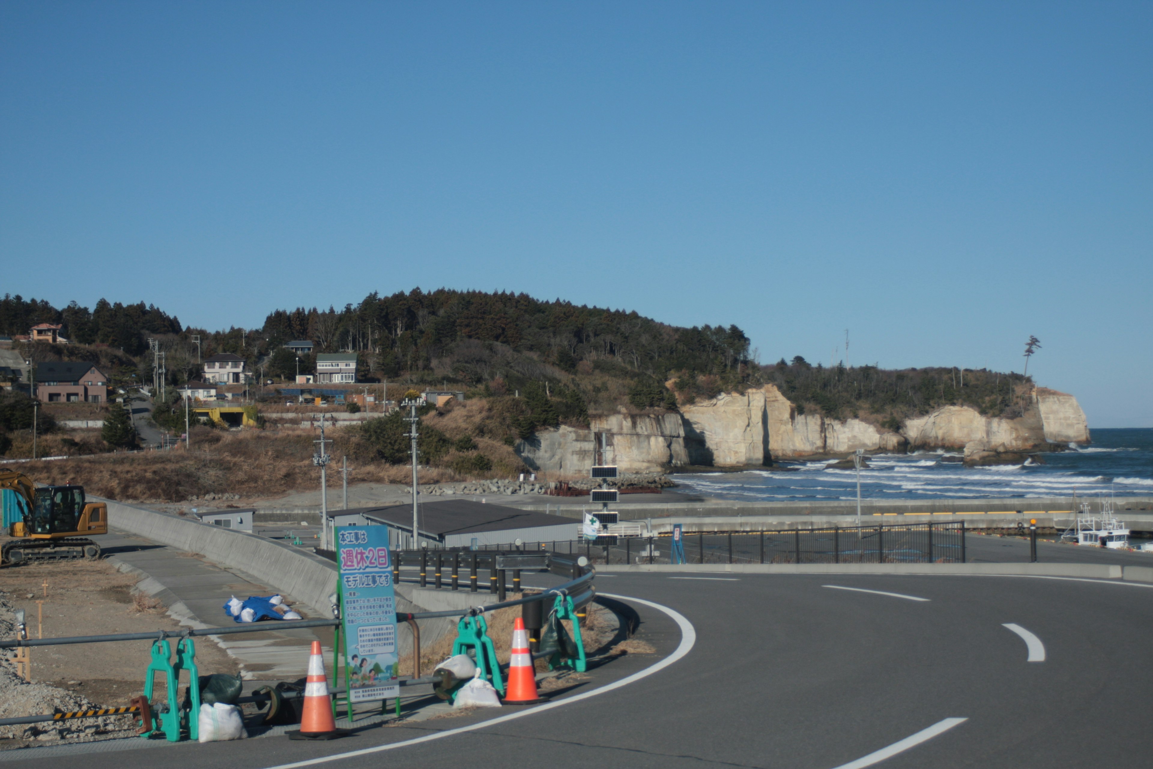 海岸沿いの道路と工事現場の風景