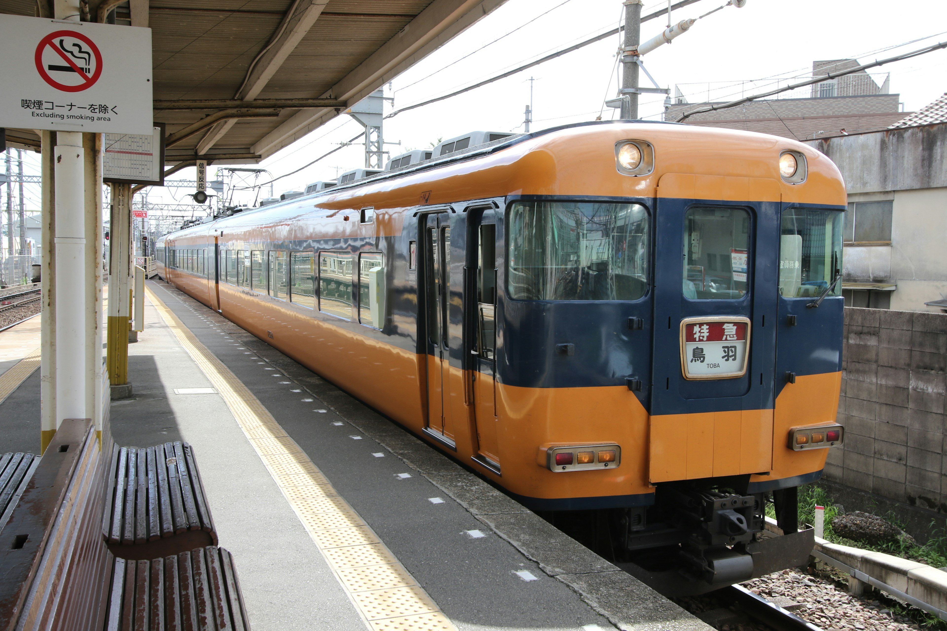 オレンジと青の列車が駅のプラットフォームに停車中