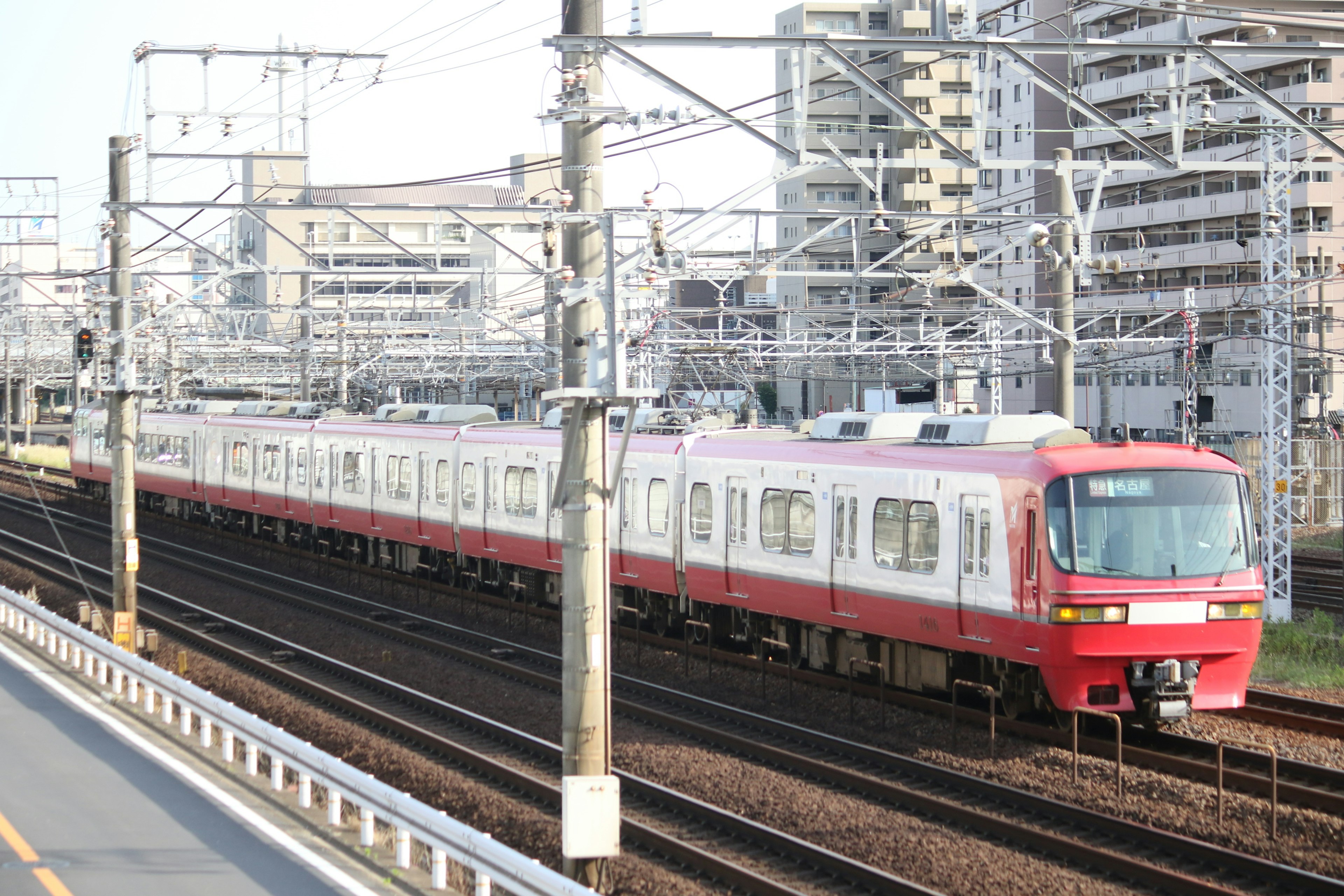 Train rouge roulant sur des rails dans un cadre urbain