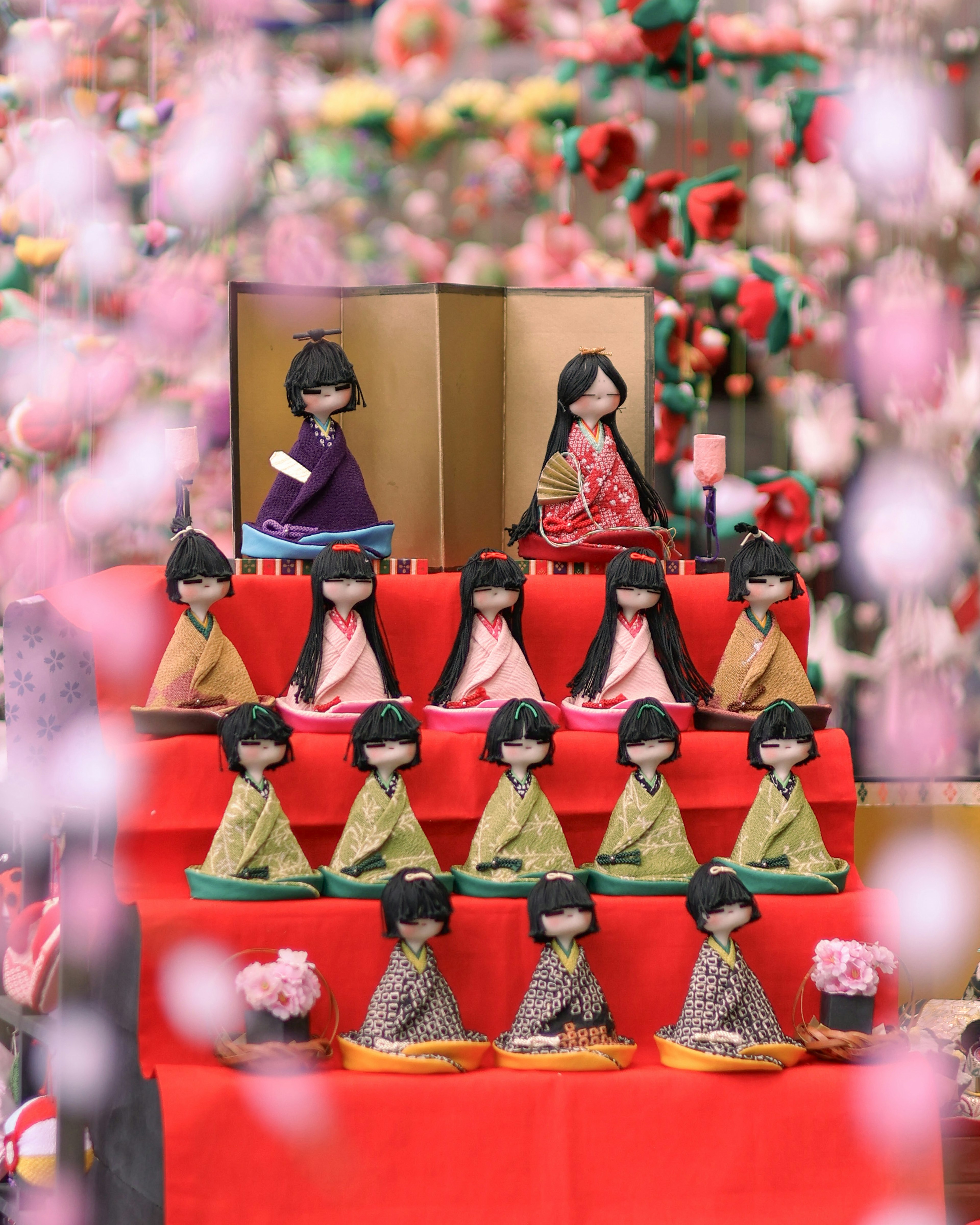 Bambole tradizionali colorate disposte in una mostra di Hinamatsuri