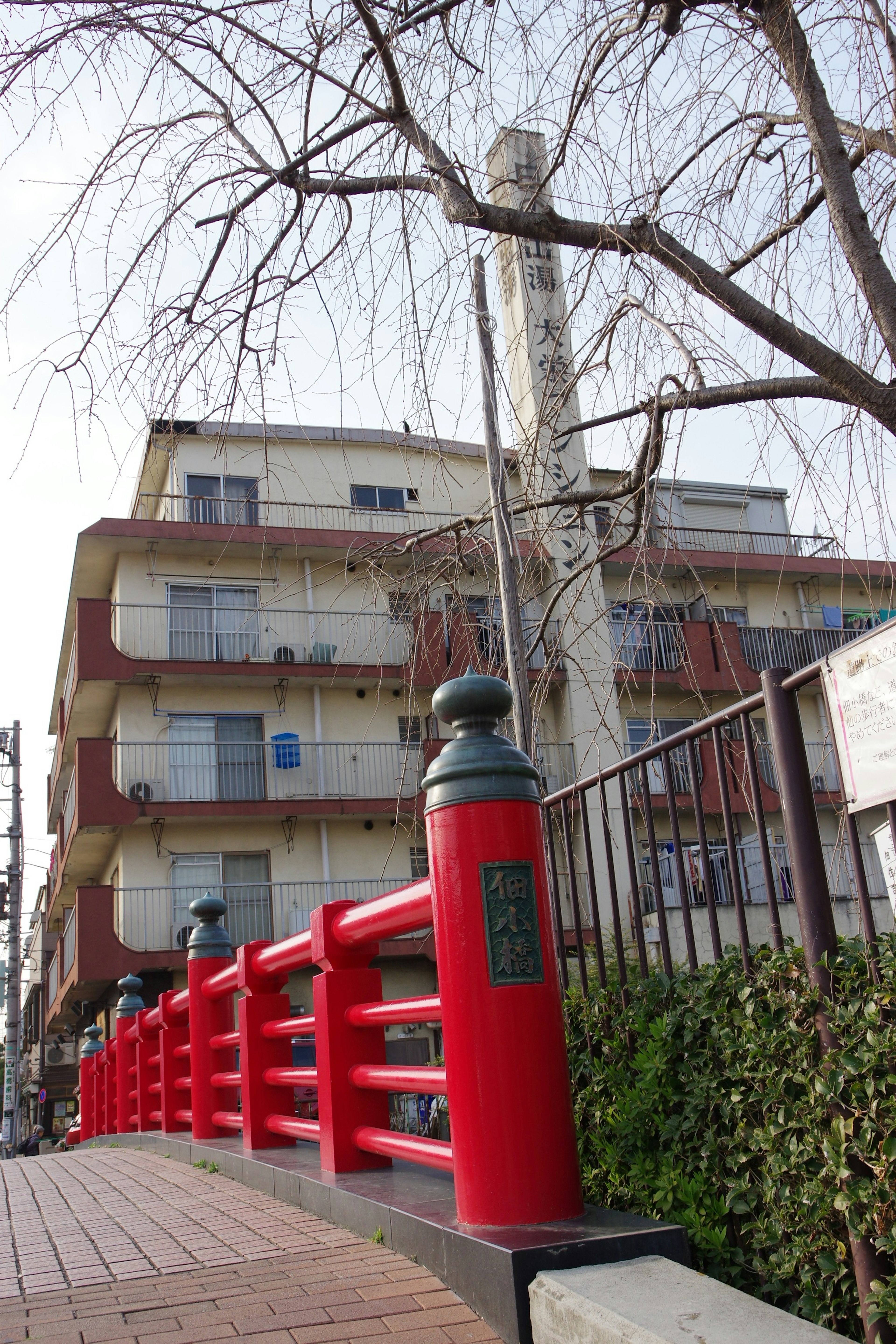 Vue pittoresque avec un pont rouge et un ancien bâtiment