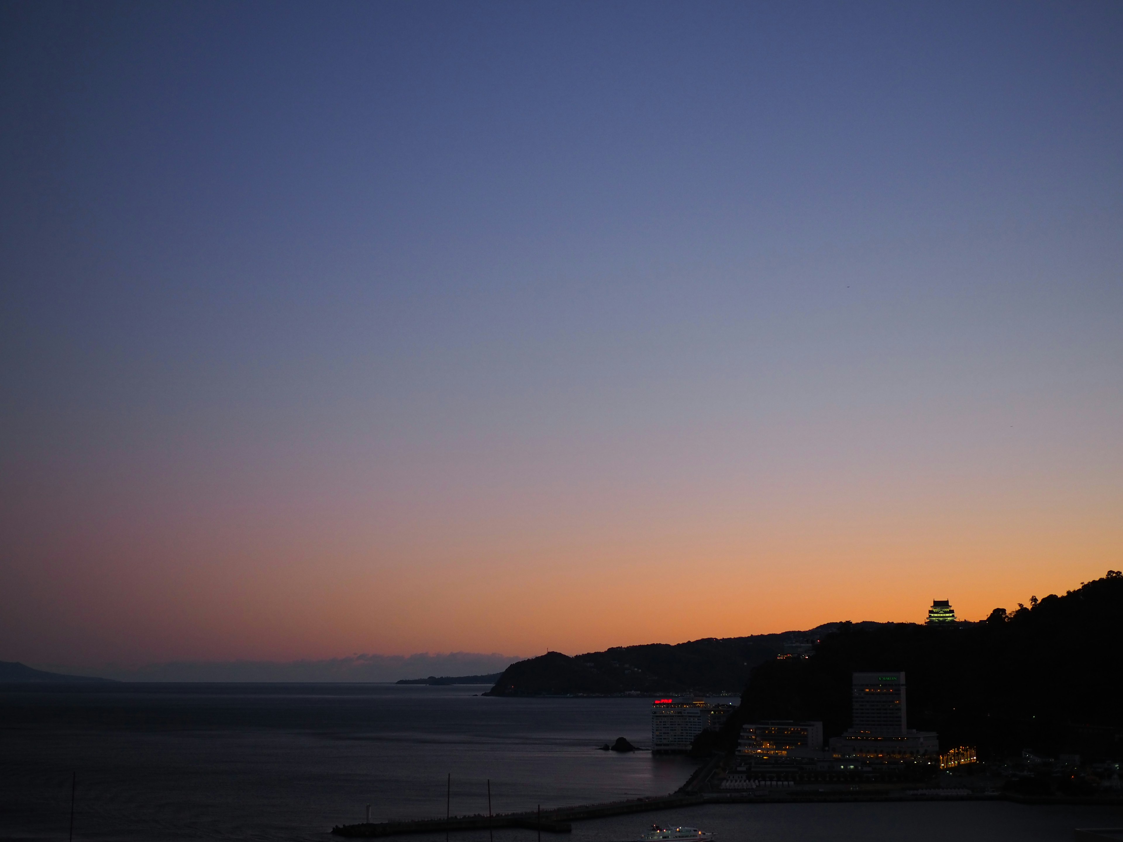 夕暮れの海と山の景色に柔らかな紫色の空