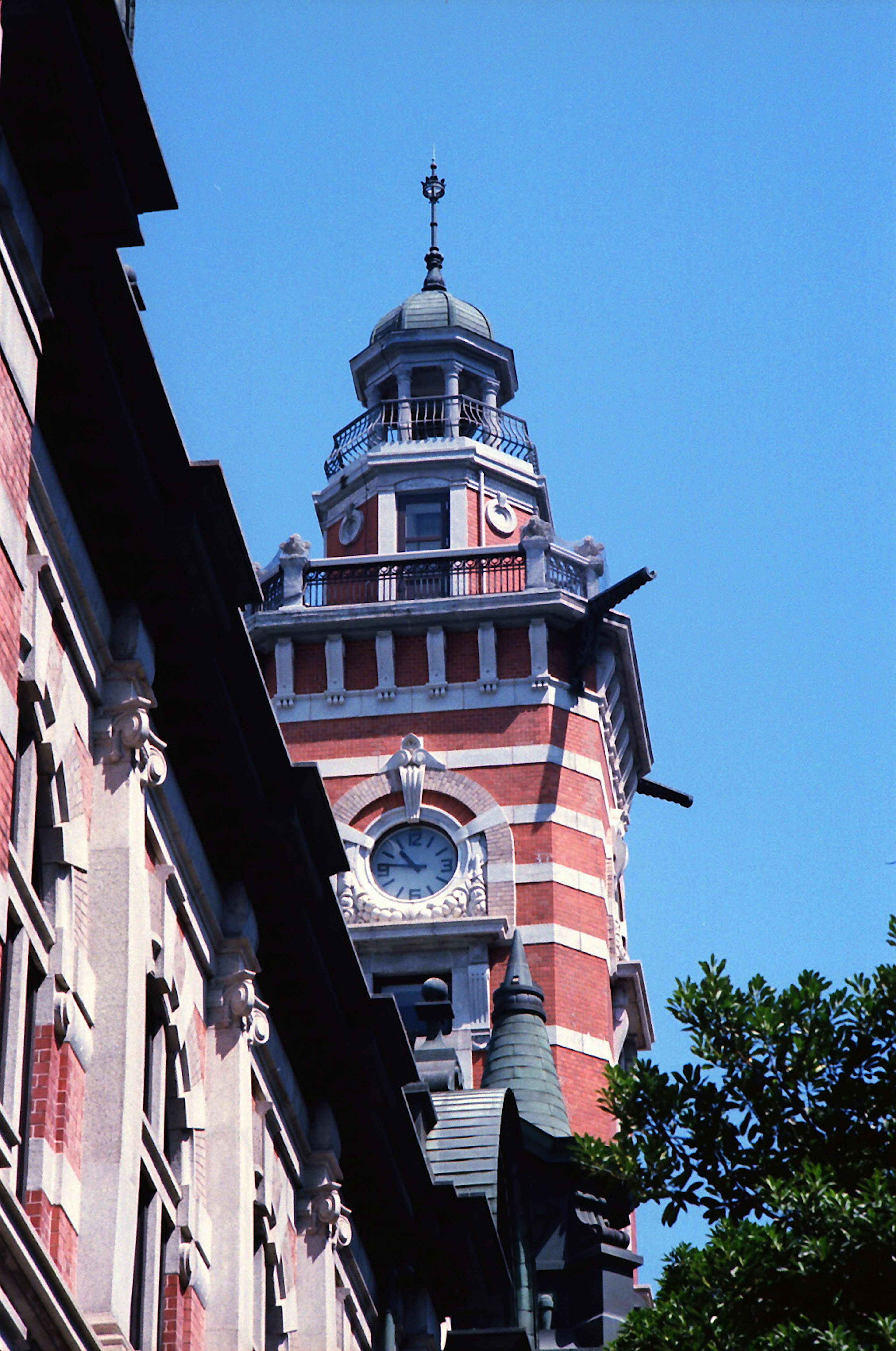 Torre del reloj de ladrillo rojo contra un cielo azul