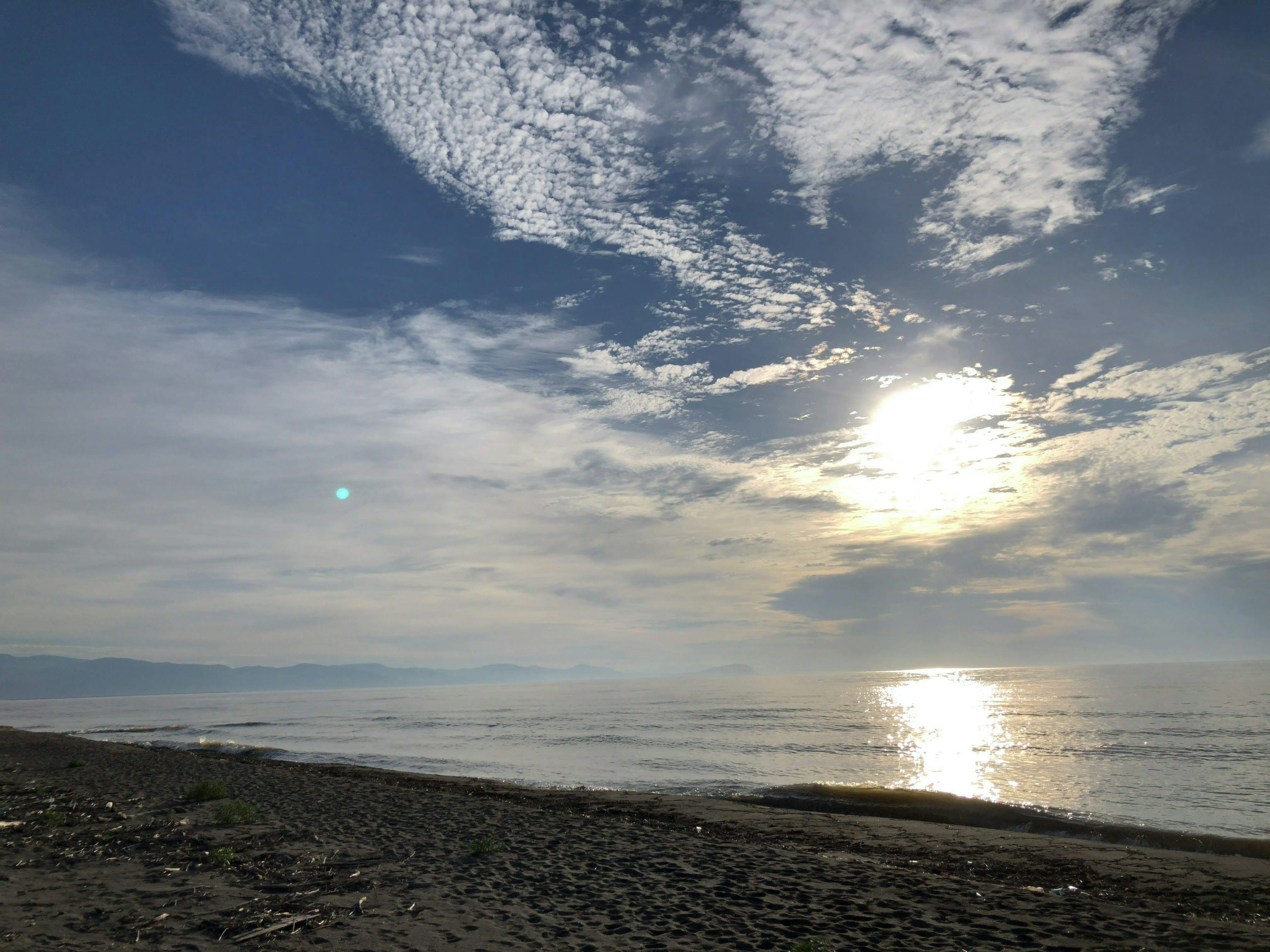 Schöne Meereslandschaft mit Wolken und Sonnenlicht, das sich auf ruhigem Wasser spiegelt