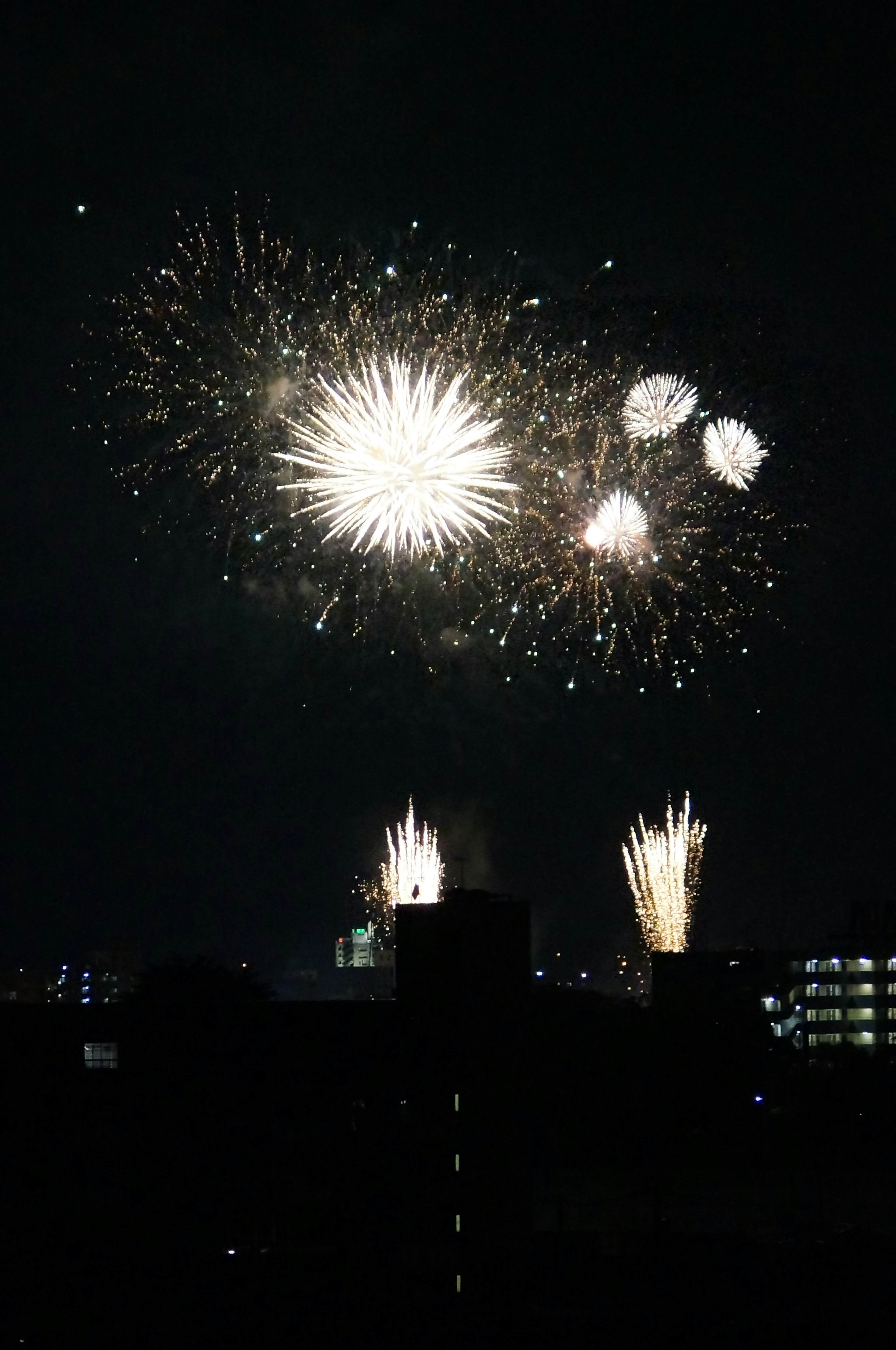 Ein Feuerwerk mit weißen Explosionen am Nachthimmel