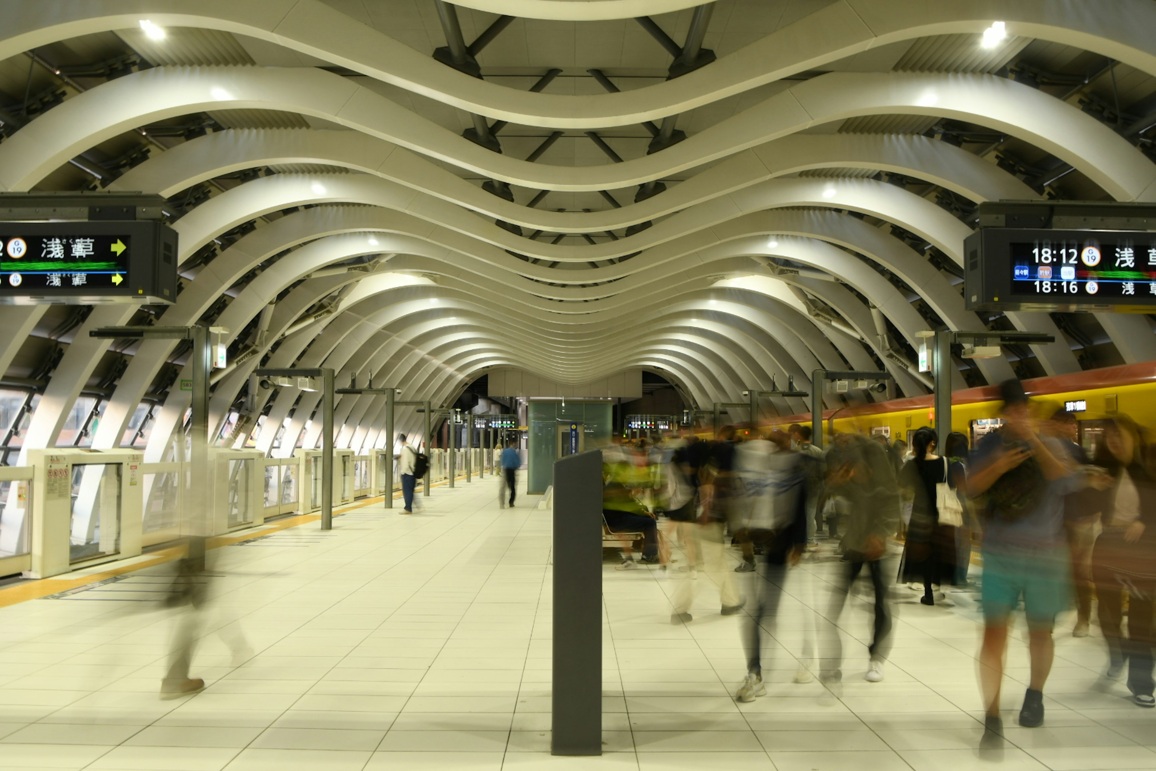 Interior stasiun kereta modern dengan kerumunan yang bergerak