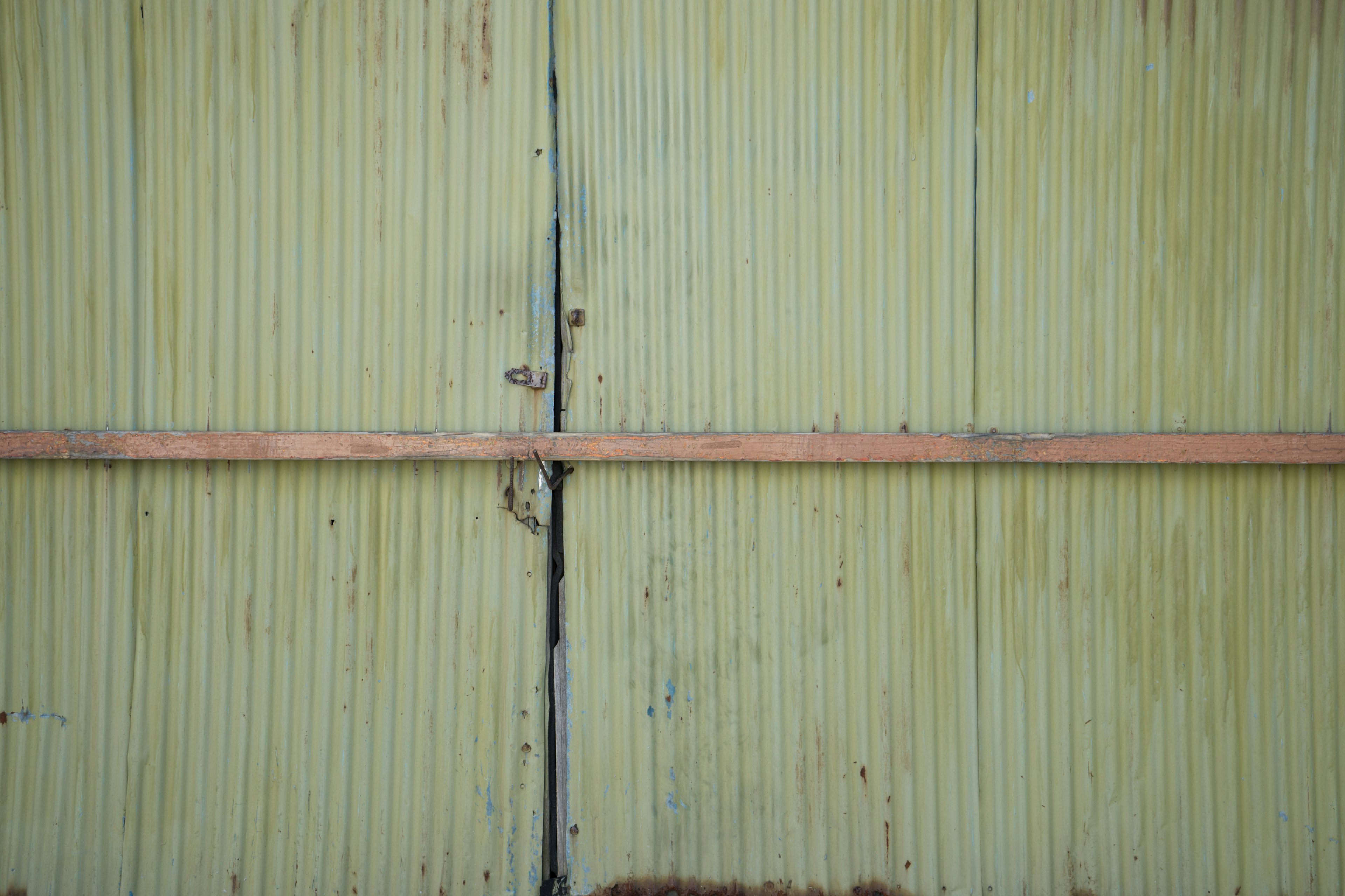 Pared amarilla con una franja metálica oxidada en el centro