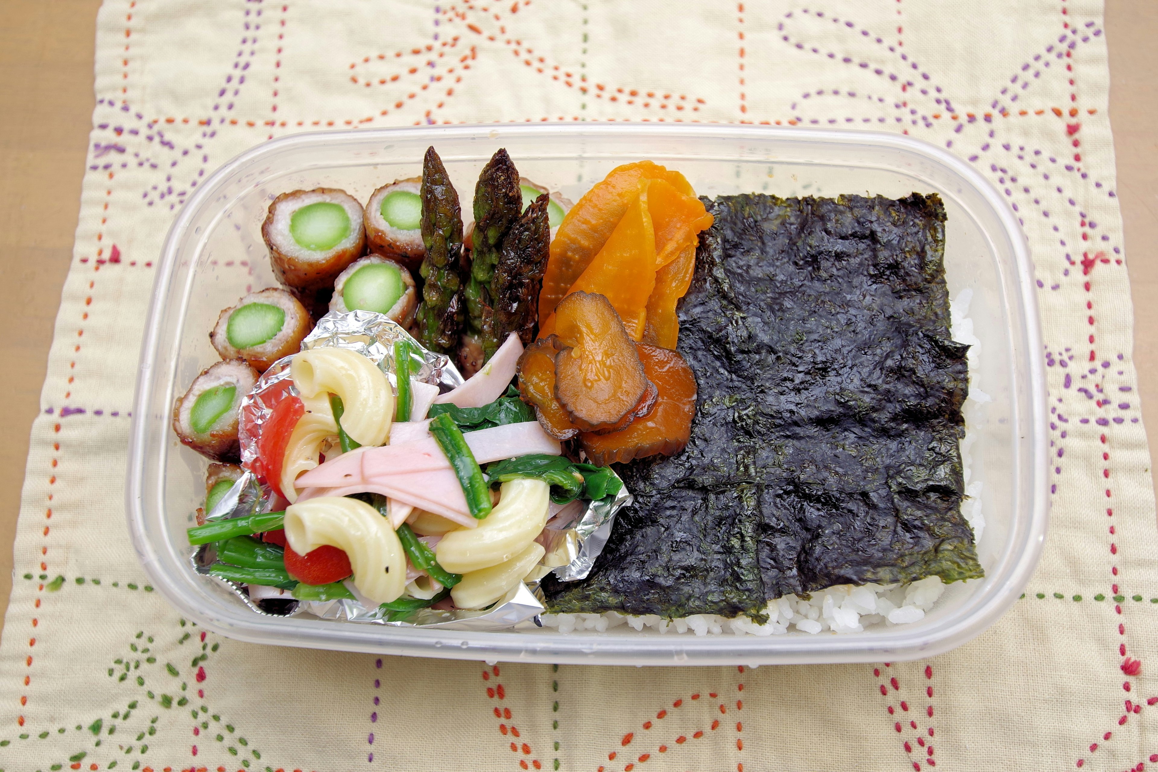 Una caja bento con arroz y varios platos de verduras