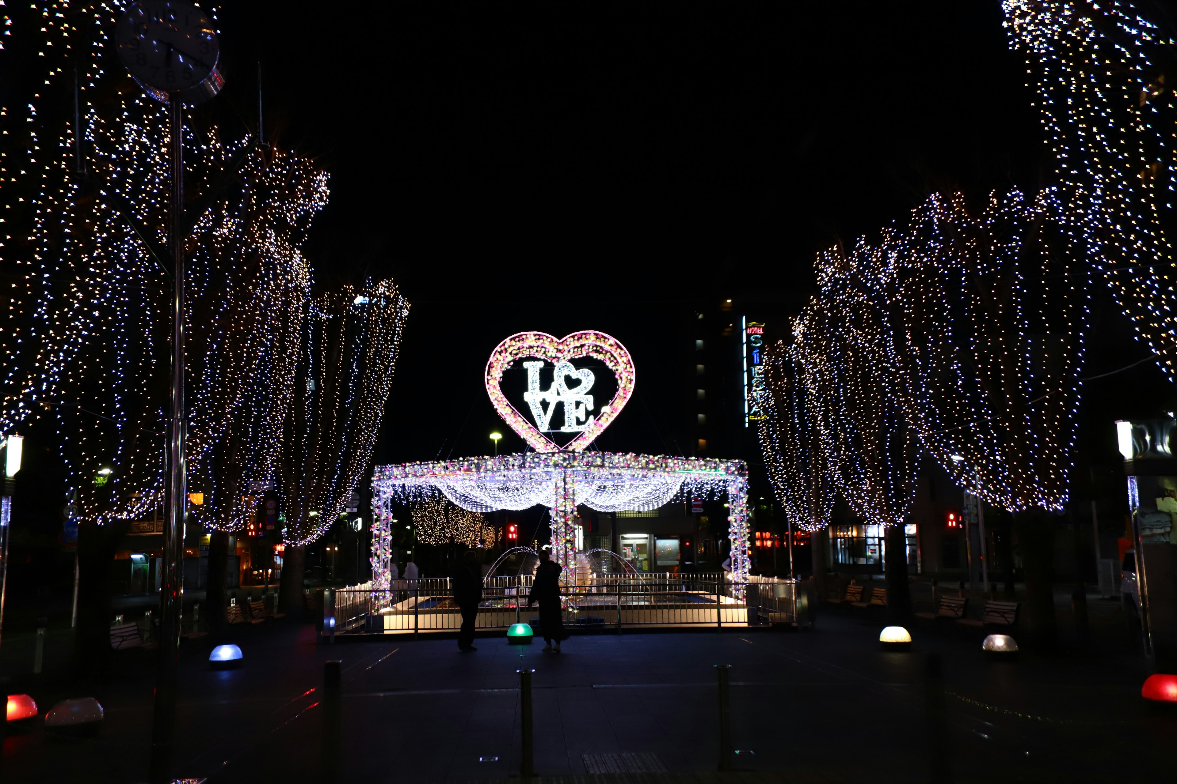 夜の街で輝くハート型のイルミネーションと美しい光のアーチ