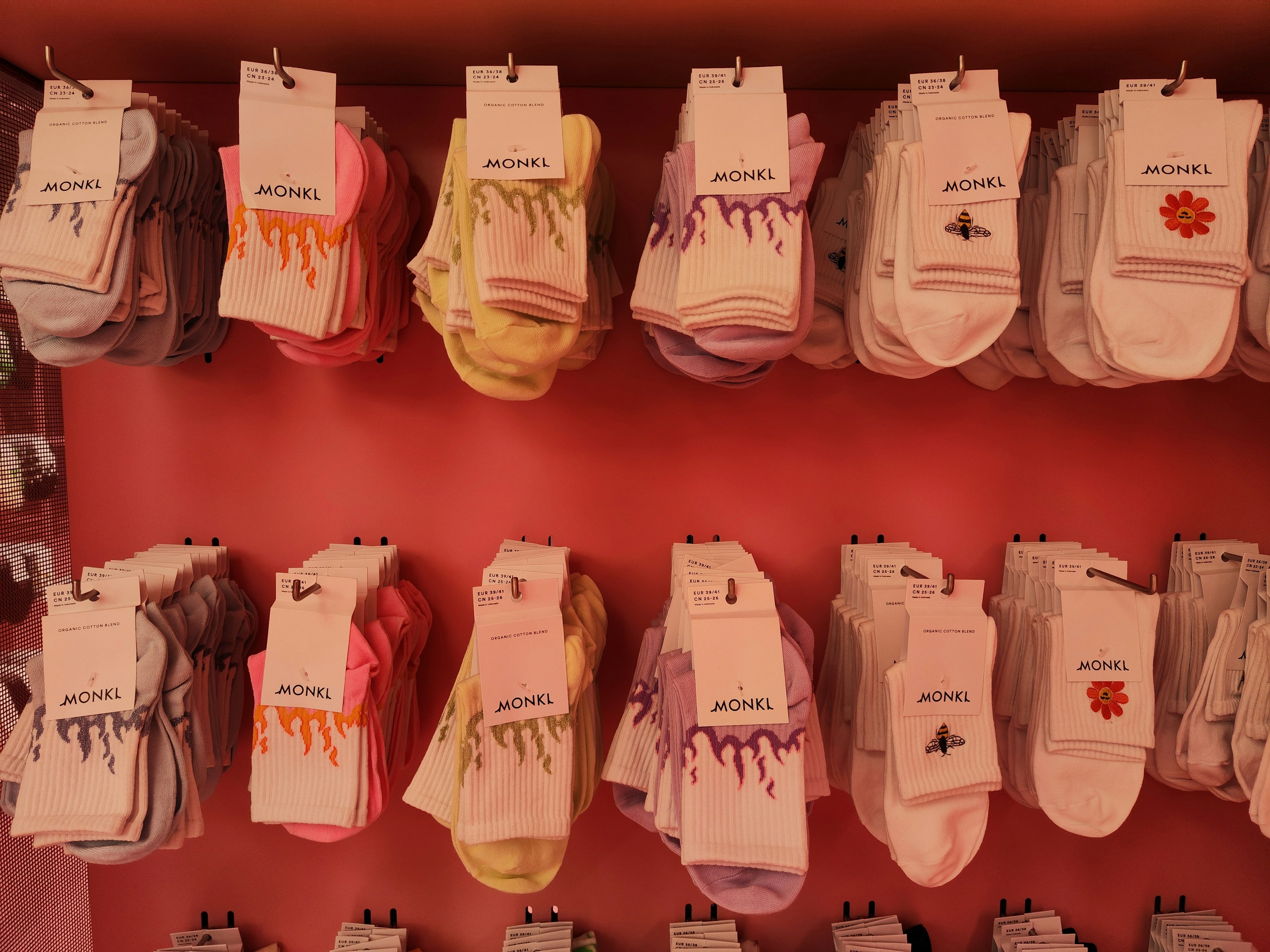 Colorful socks displayed on a pink wall