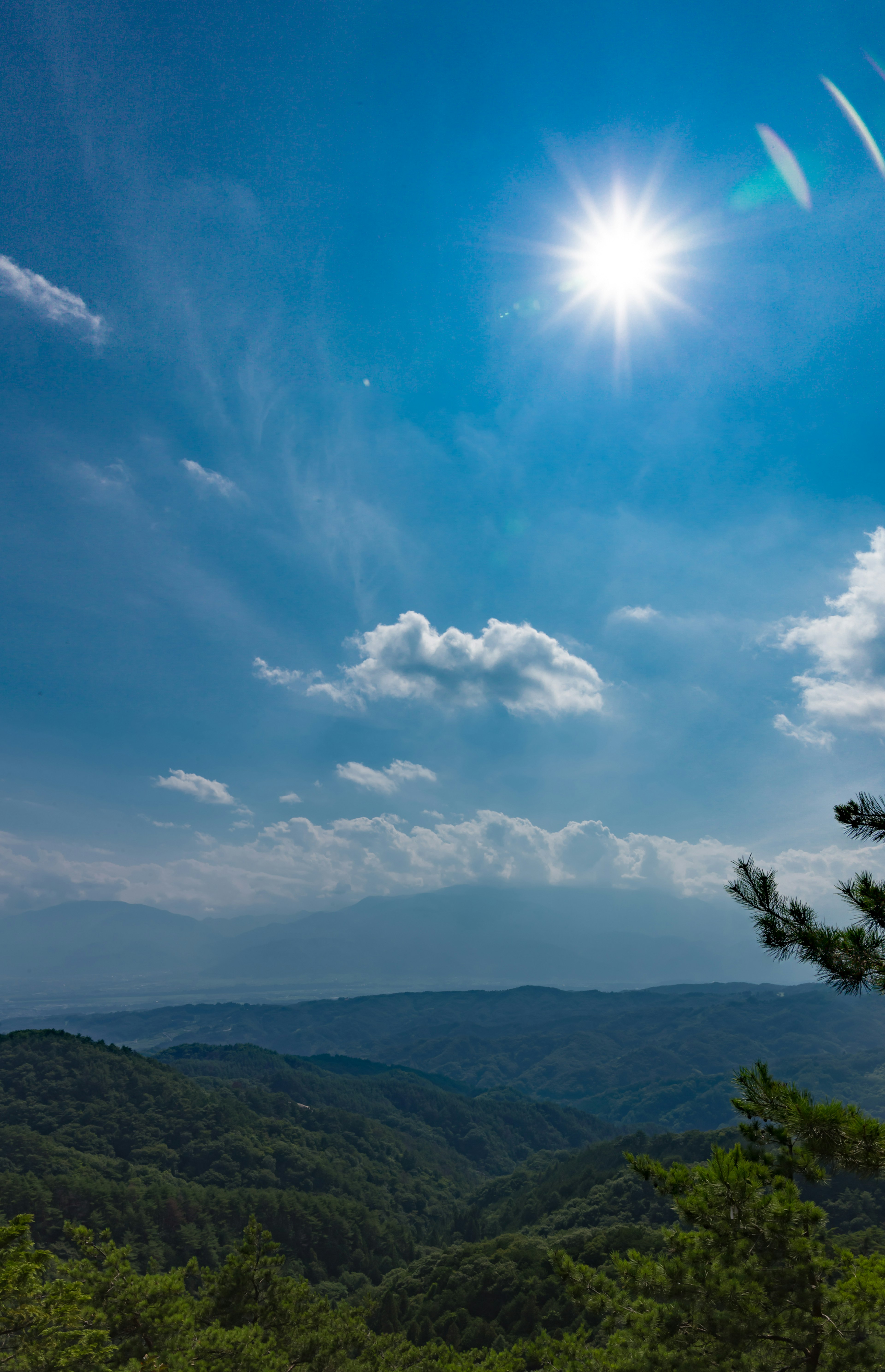 Pemandangan pegunungan dengan langit biru dan awan matahari bersinar