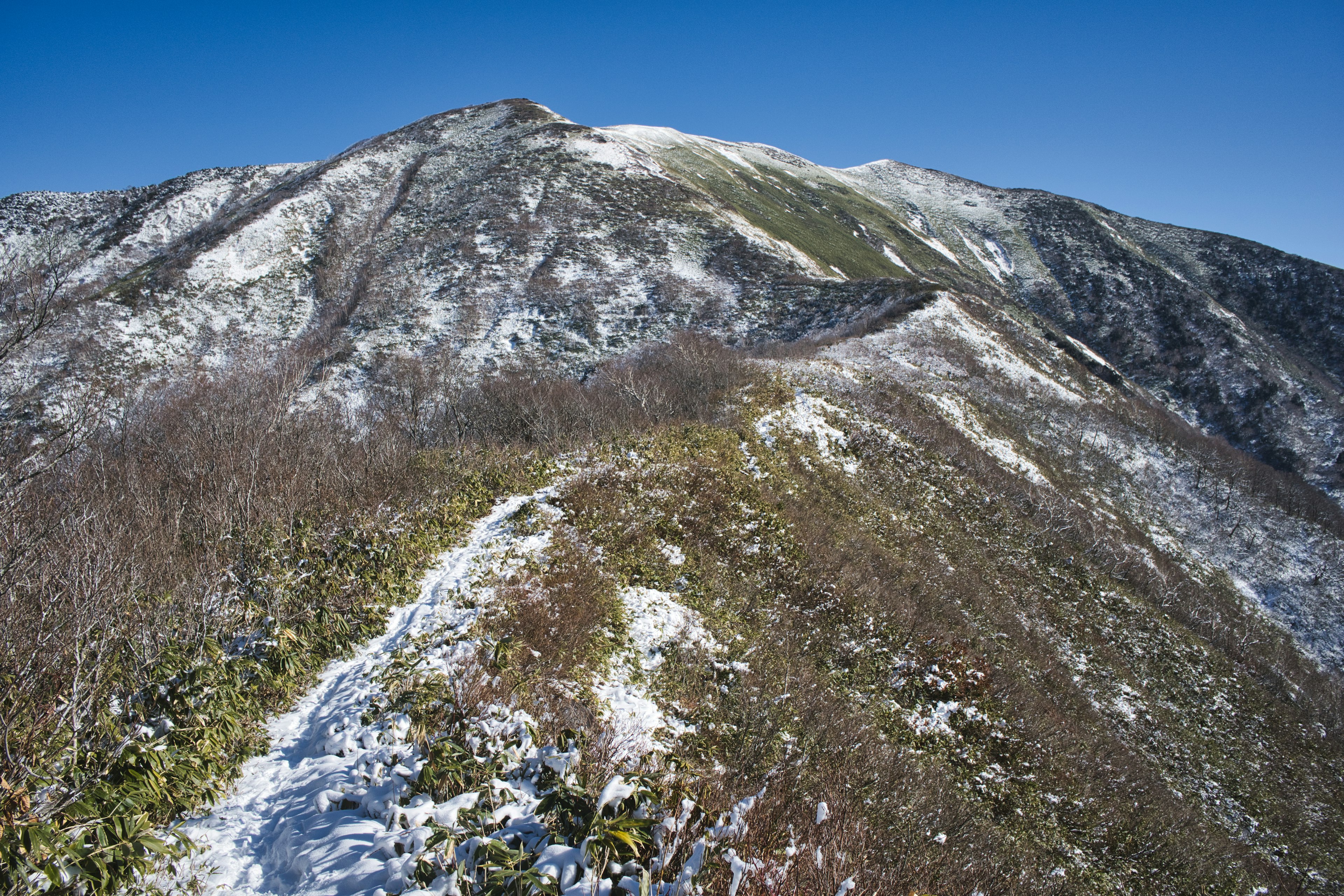 Paesaggio montano innevato con cielo blu terso