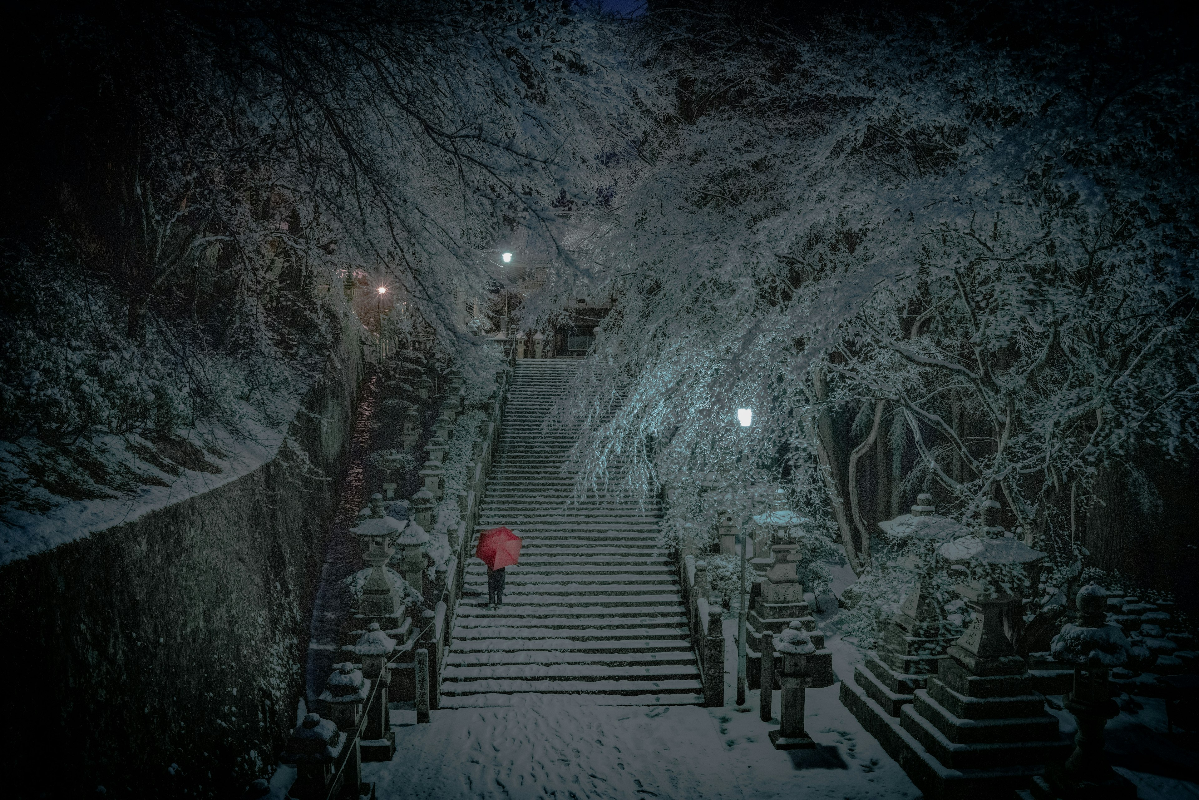 Image of a person in a red coat climbing snow-covered stairs