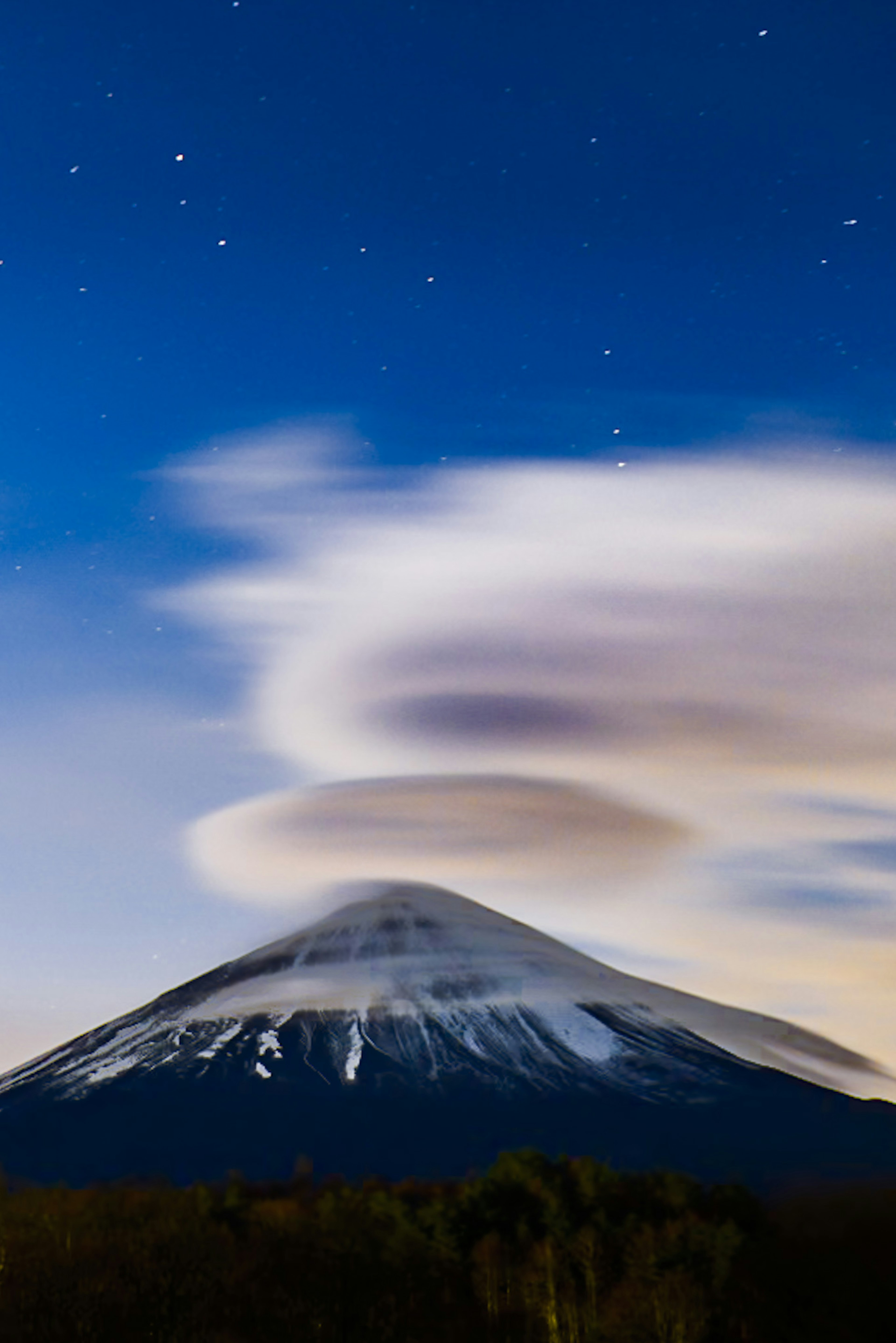 Mount Fuji with a snow-capped peak under a starry night sky