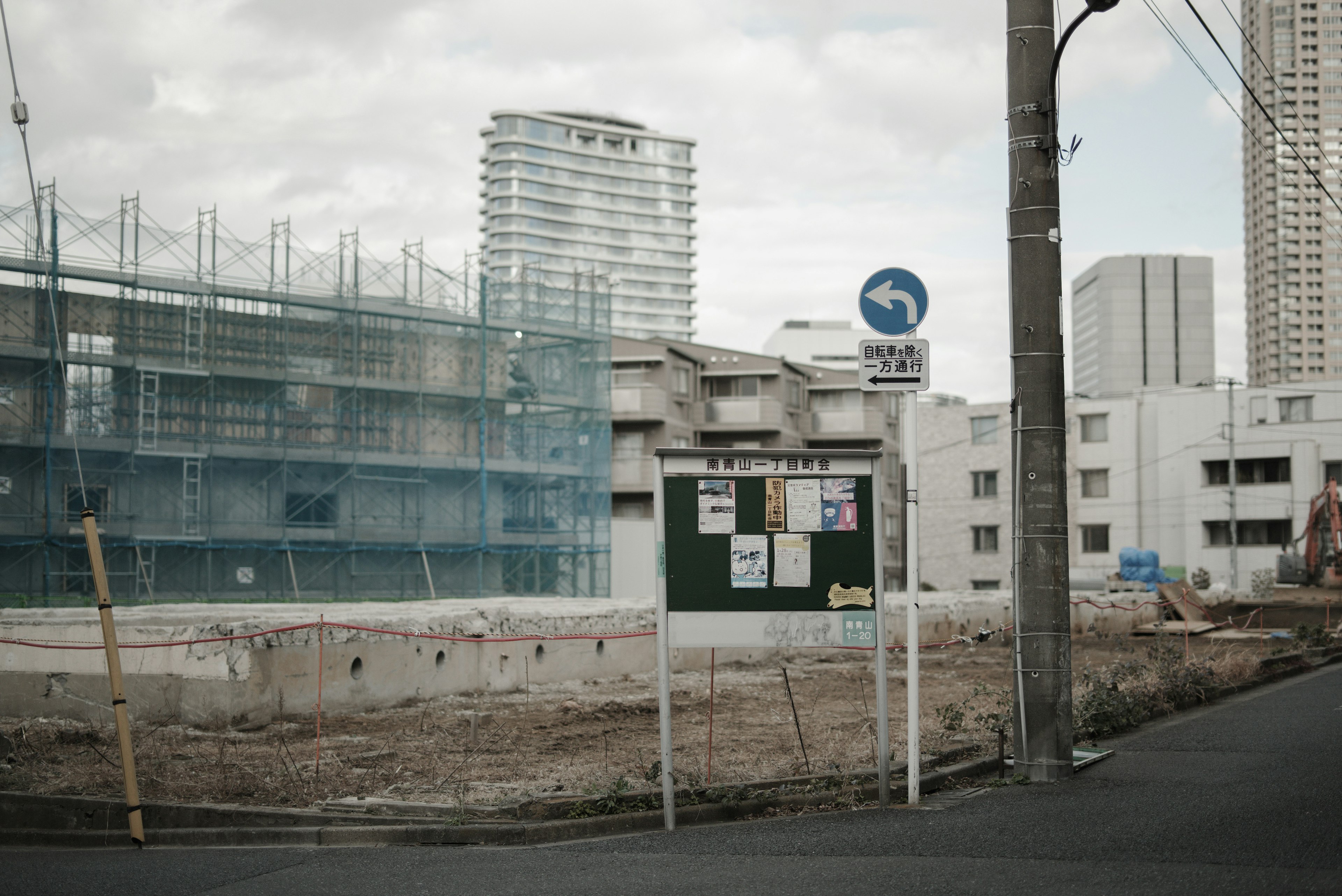 Urban scene featuring a construction site and a construction sign