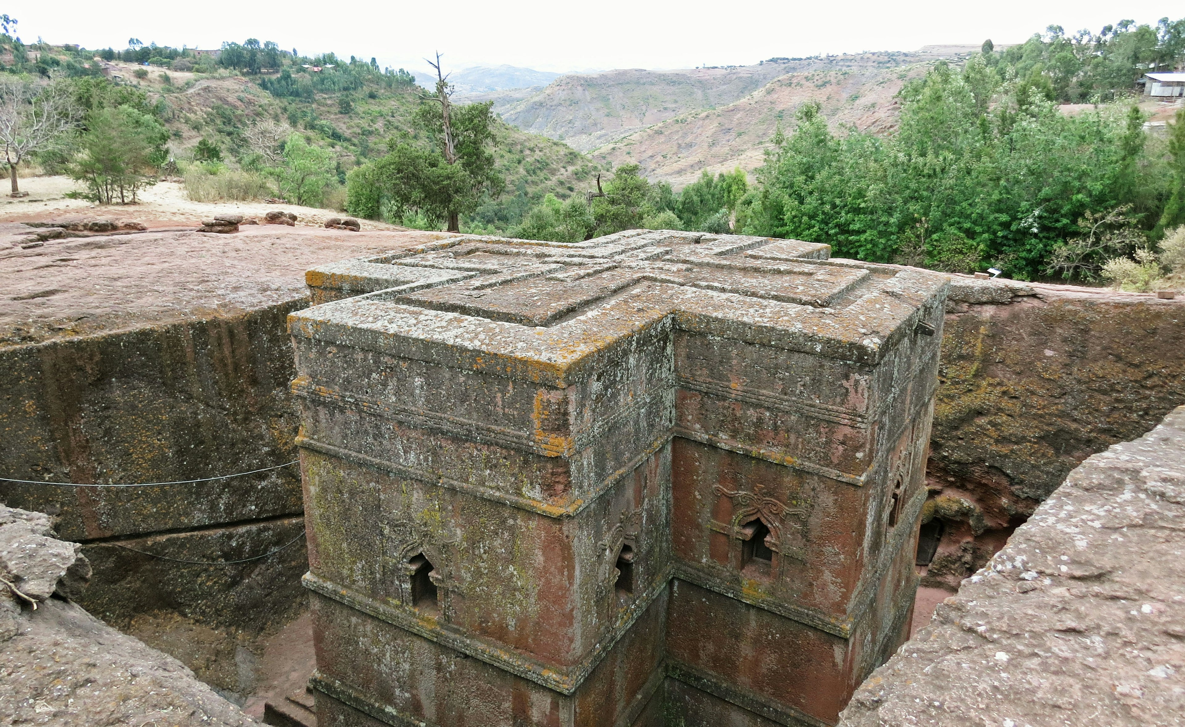 古代の石造りの建築物の一部が見える風景 磨かれた石のブロックと周囲の緑の風景