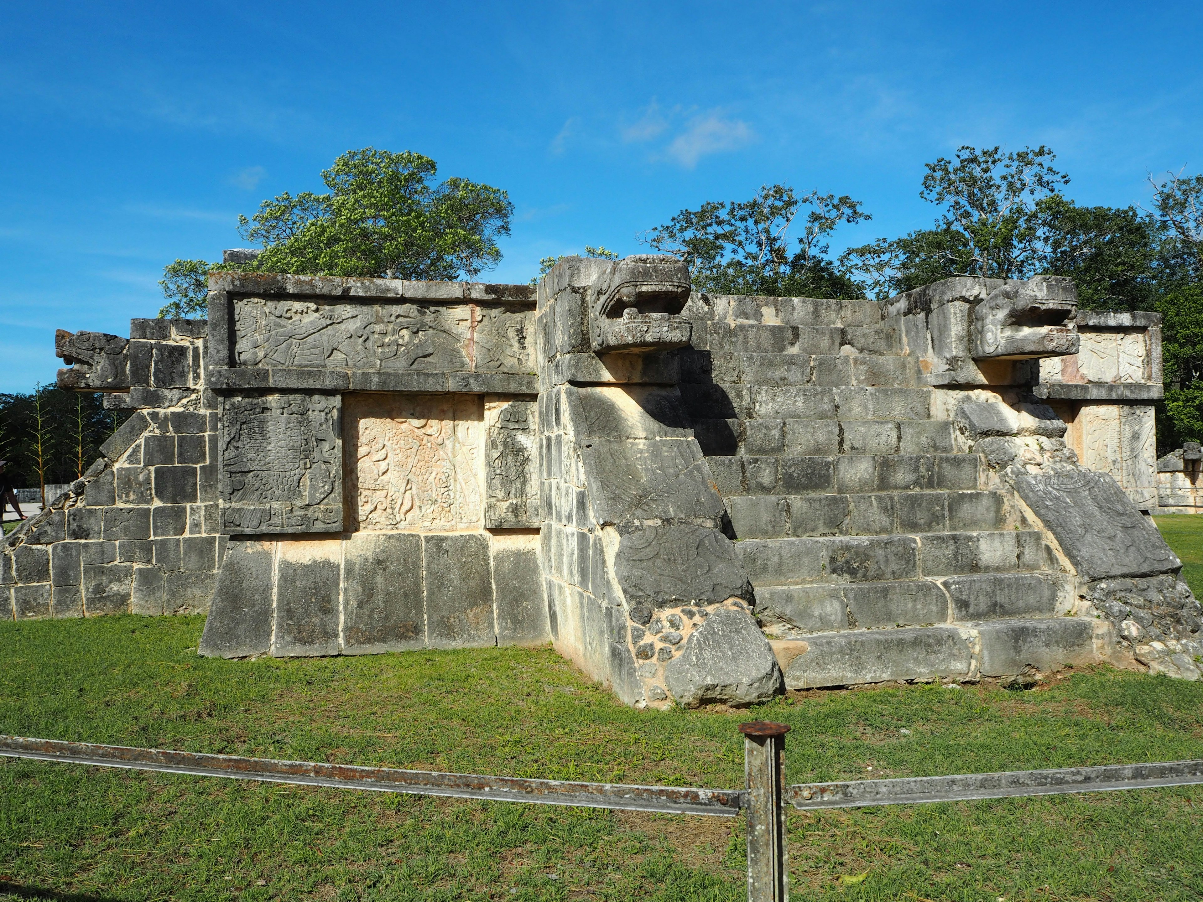 Ruinas mayas antiguas con escaleras de piedra y cabezas talladas