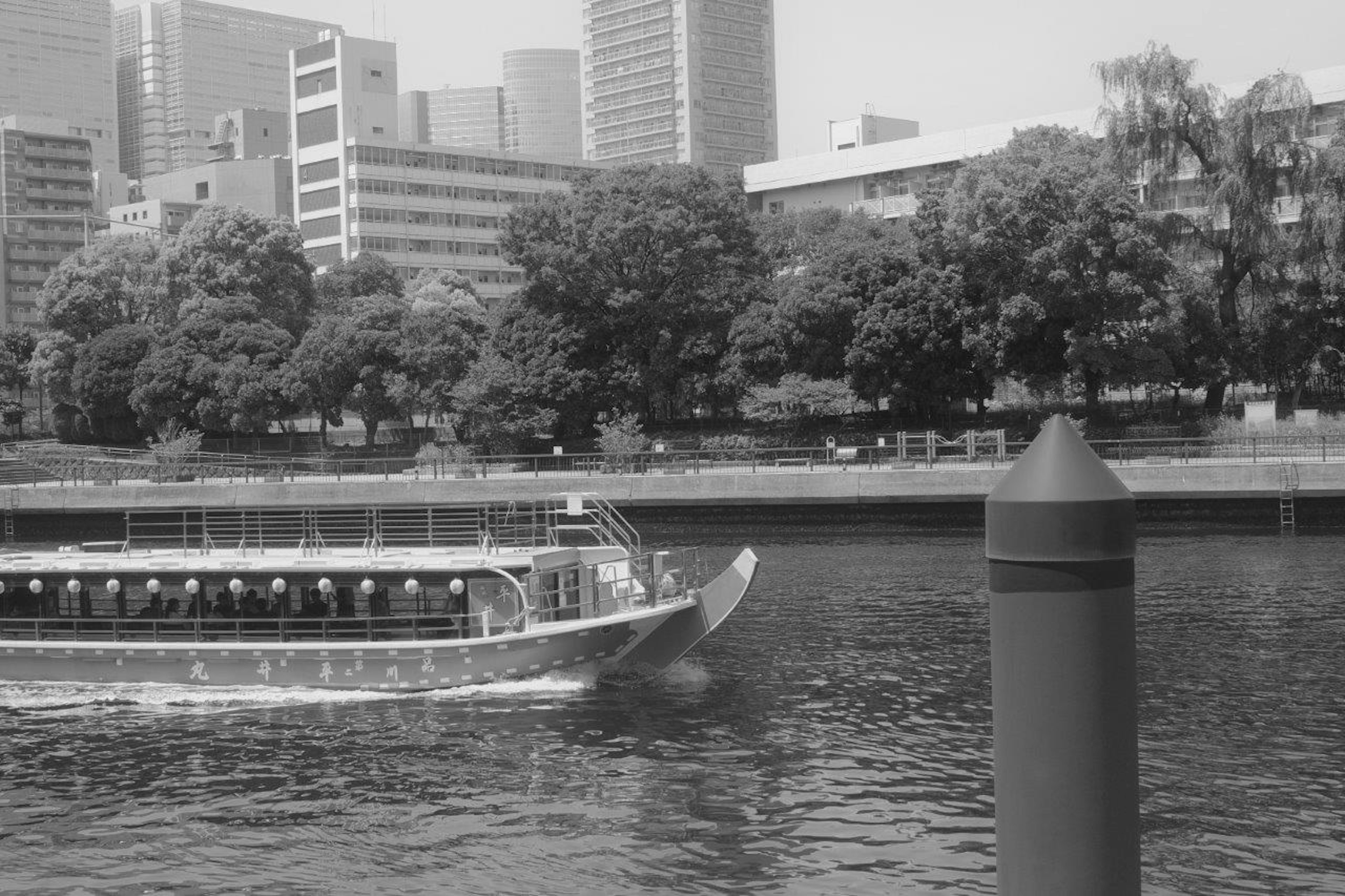 Boot fährt den Fluss entlang mit der Skyline der Stadt im Hintergrund