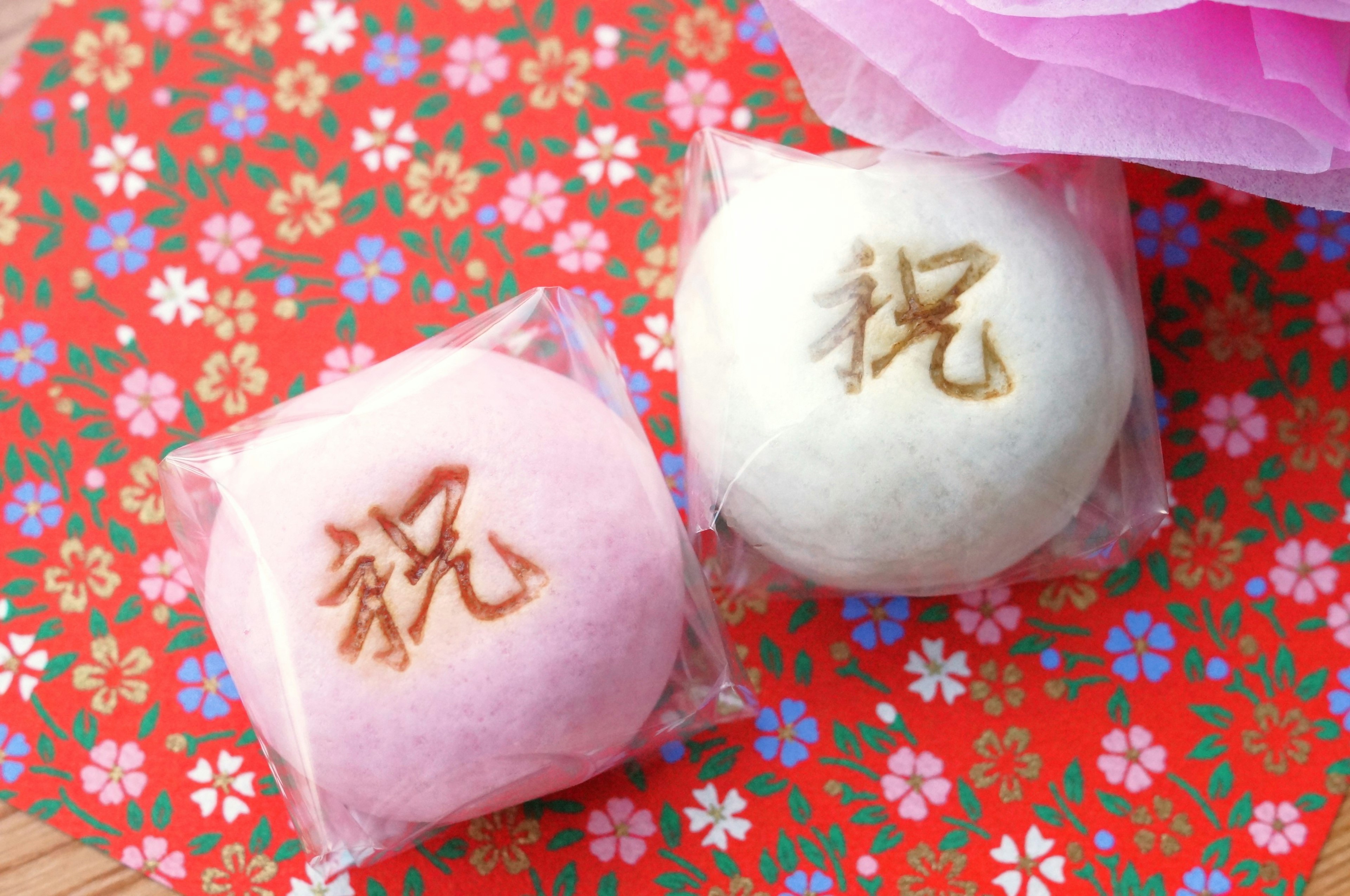 Pink and white steamed buns placed on a floral patterned background