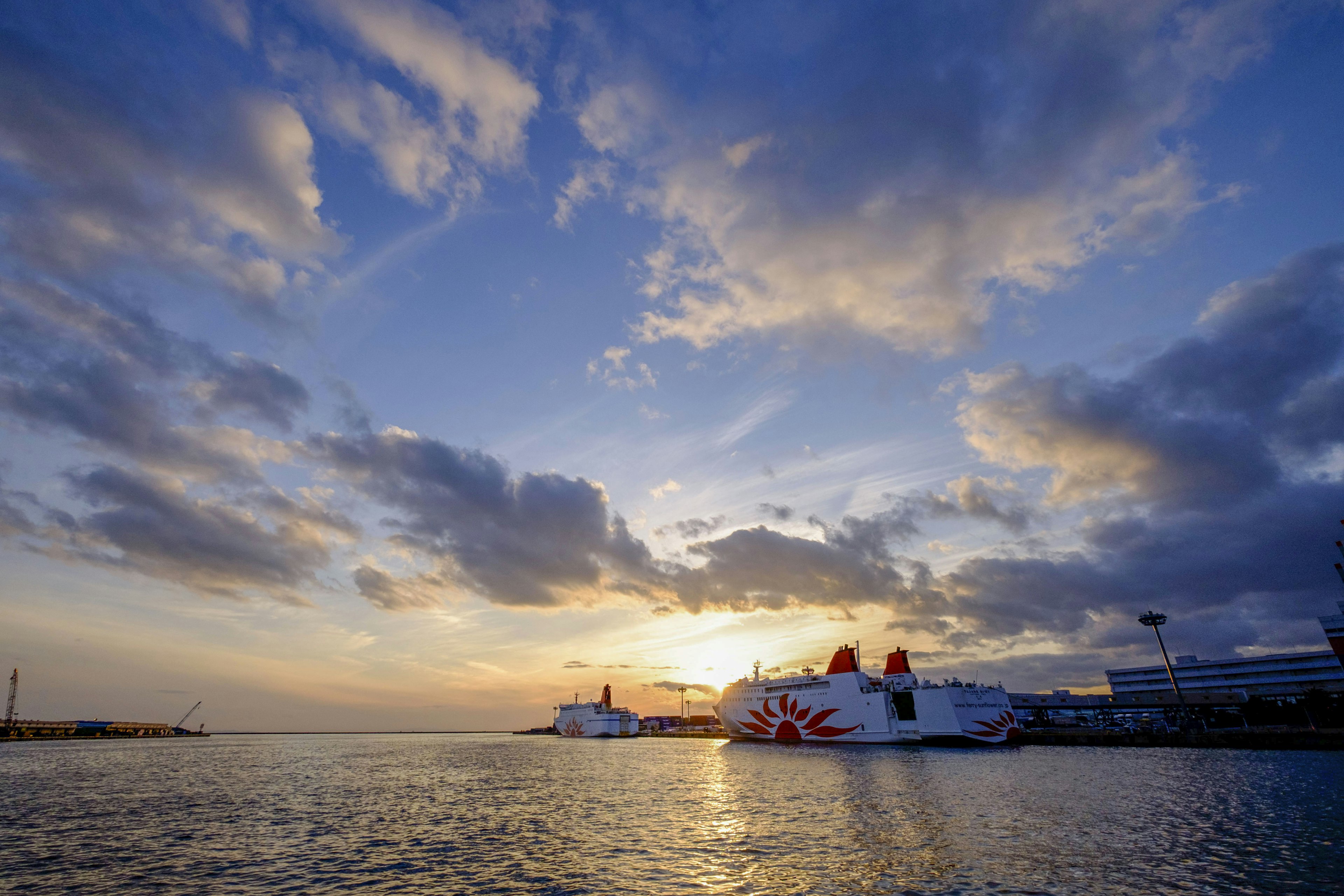 Tramonto sul mare con barche e belle nuvole