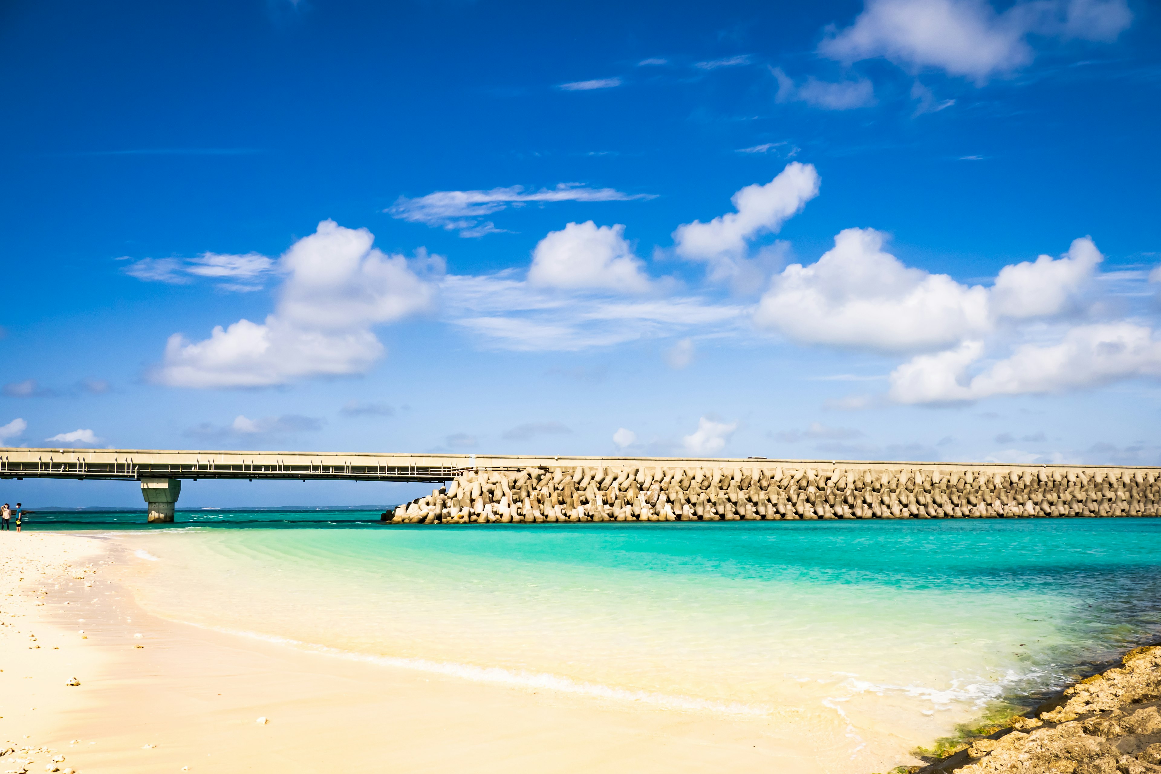 Beautiful beach with turquoise water and a bridge under a blue sky