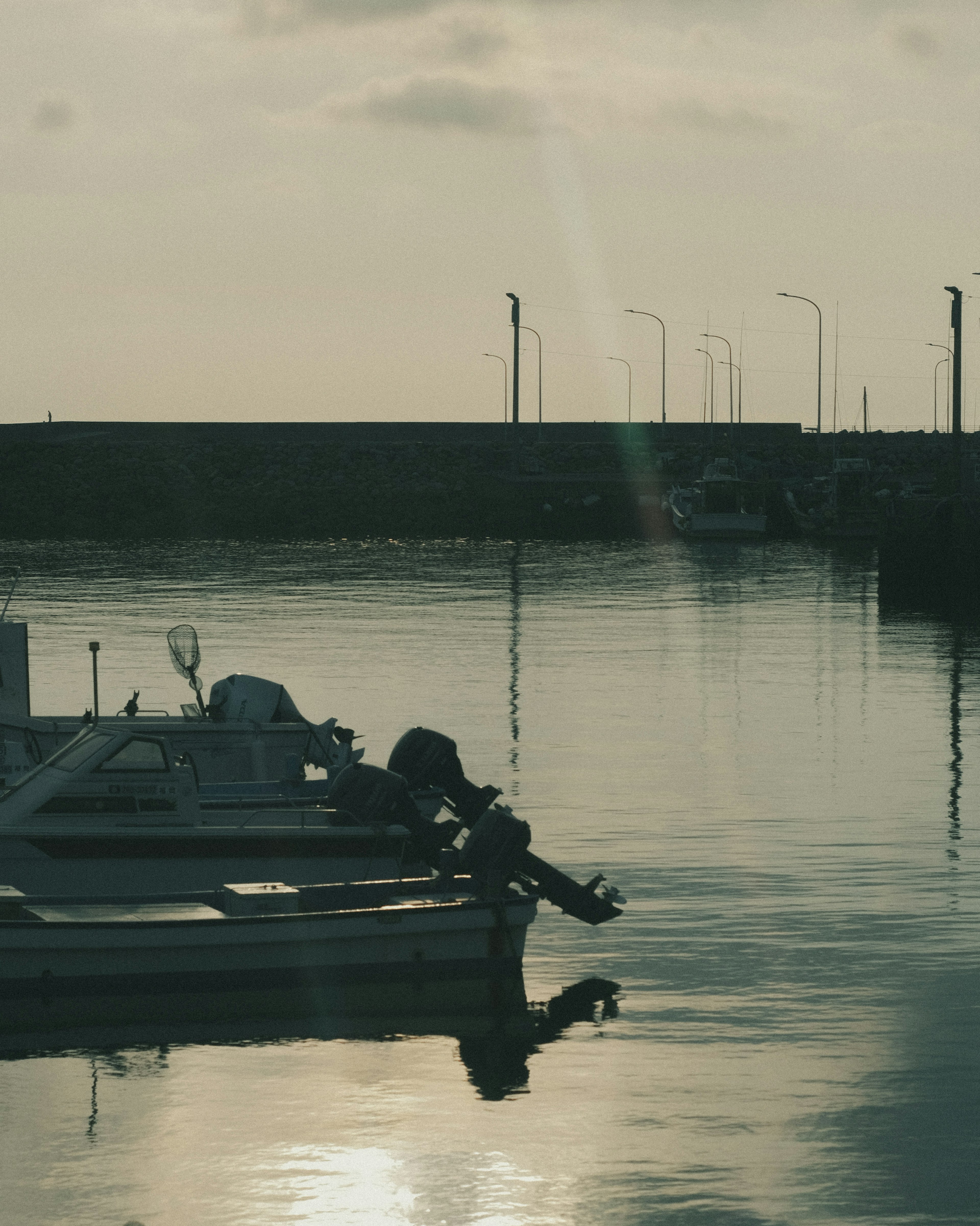 Silhouette of a person on a boat reflected on a calm water surface