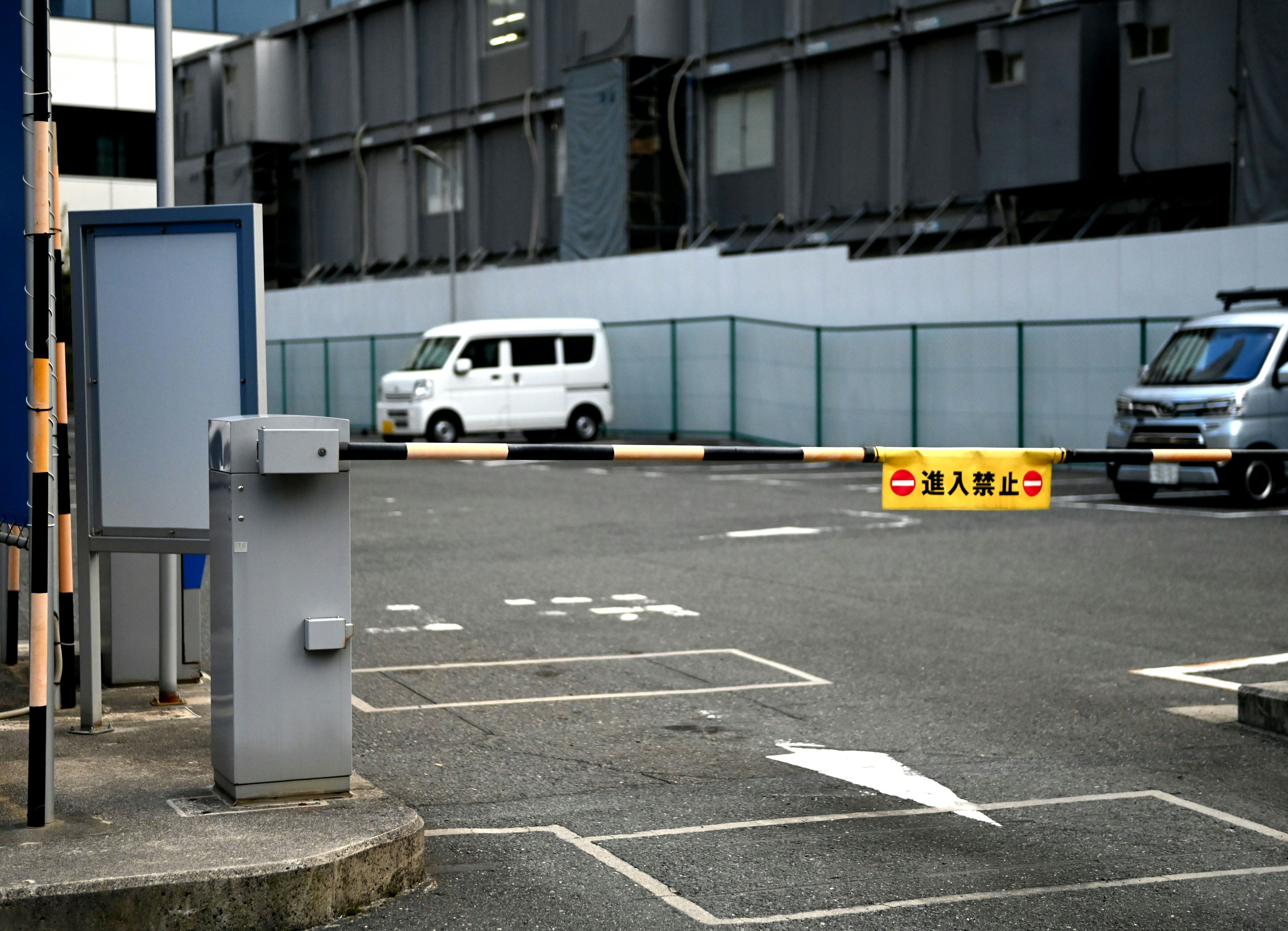 Un'area di parcheggio con un furgone bianco e un veicolo blu