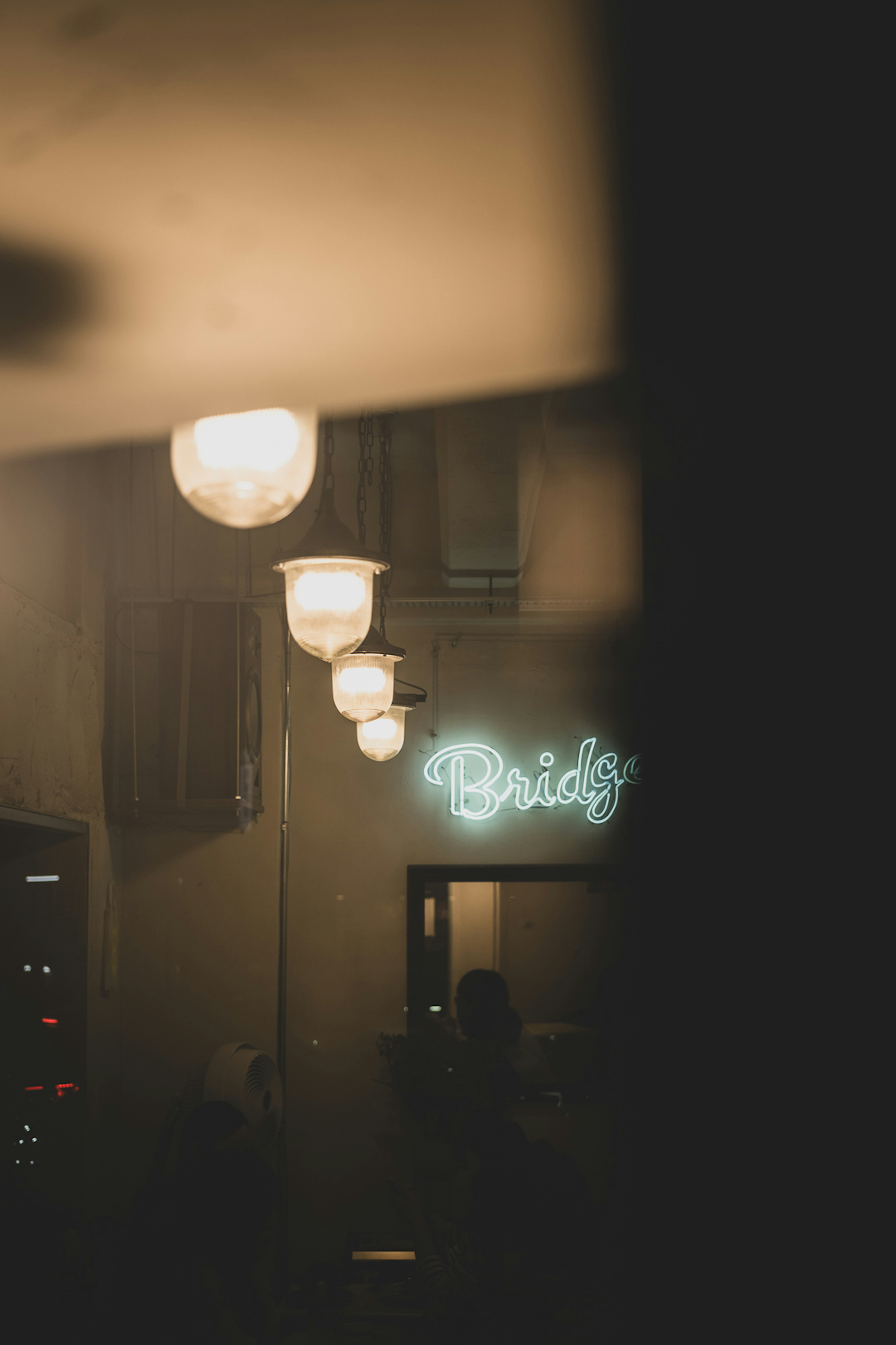 Interior view featuring bright lamps and a blue neon sign that reads 'Bridgy'