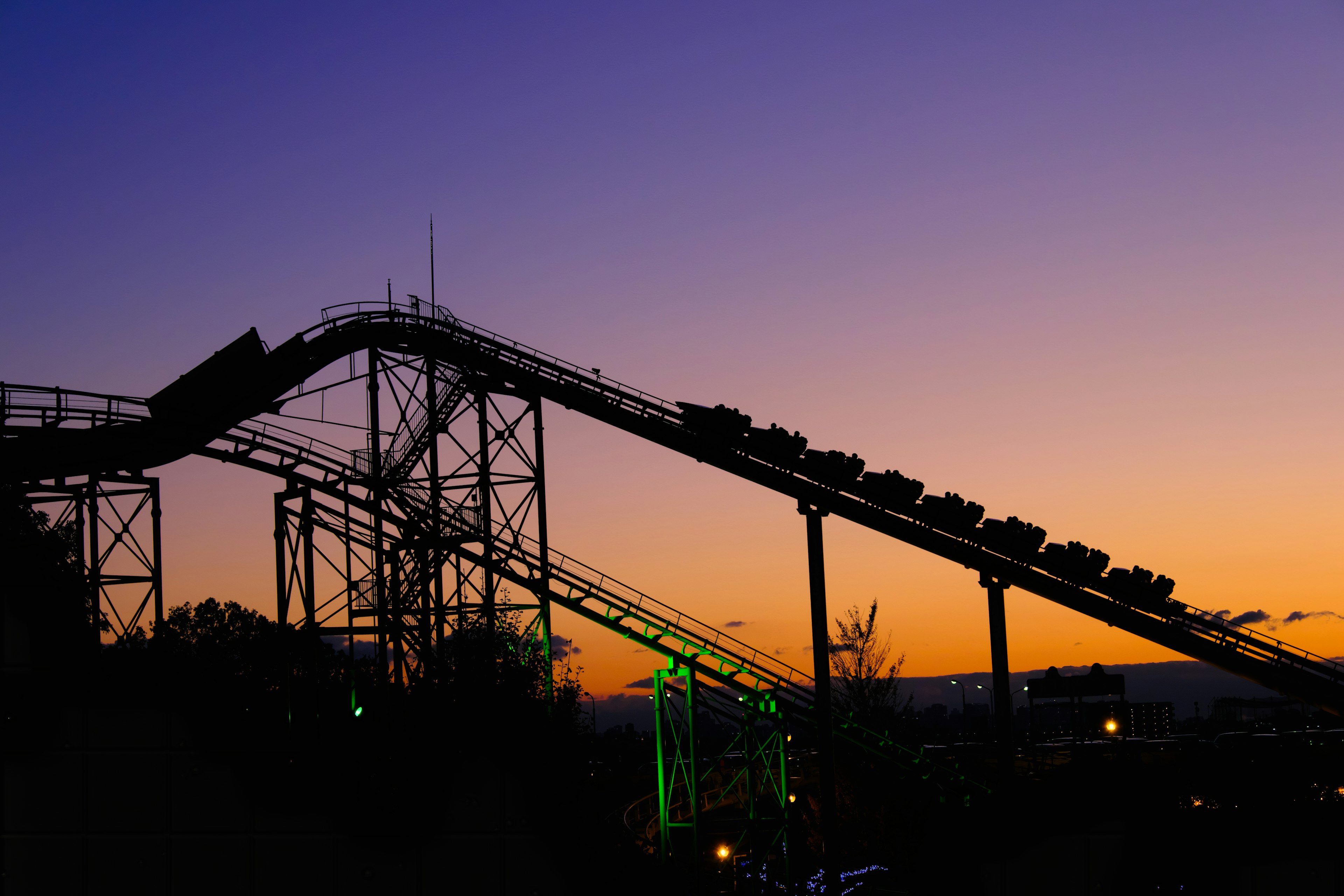 Silhouette of a roller coaster against a sunset sky