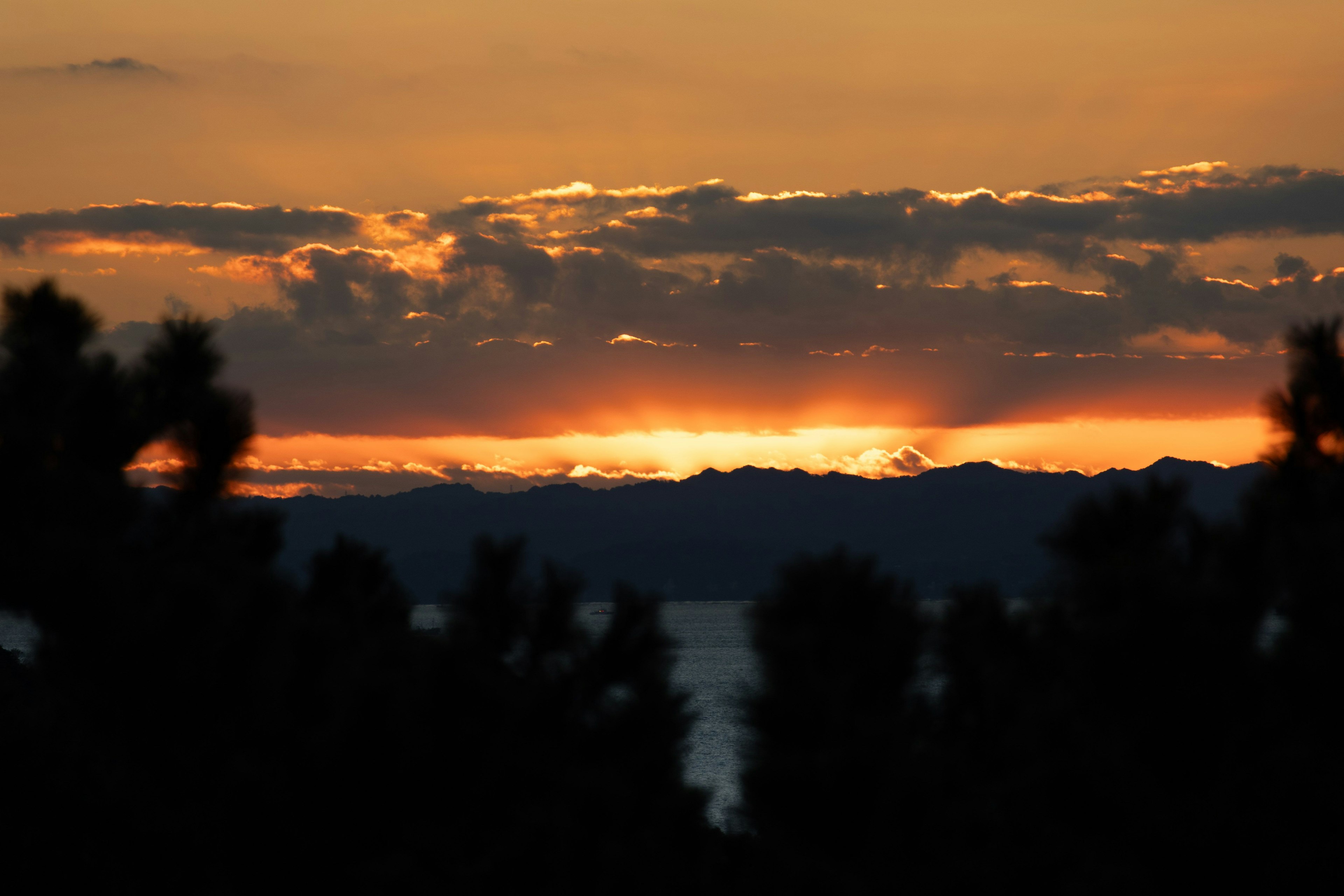夕焼けの美しい風景 山々と海のシルエットが見える