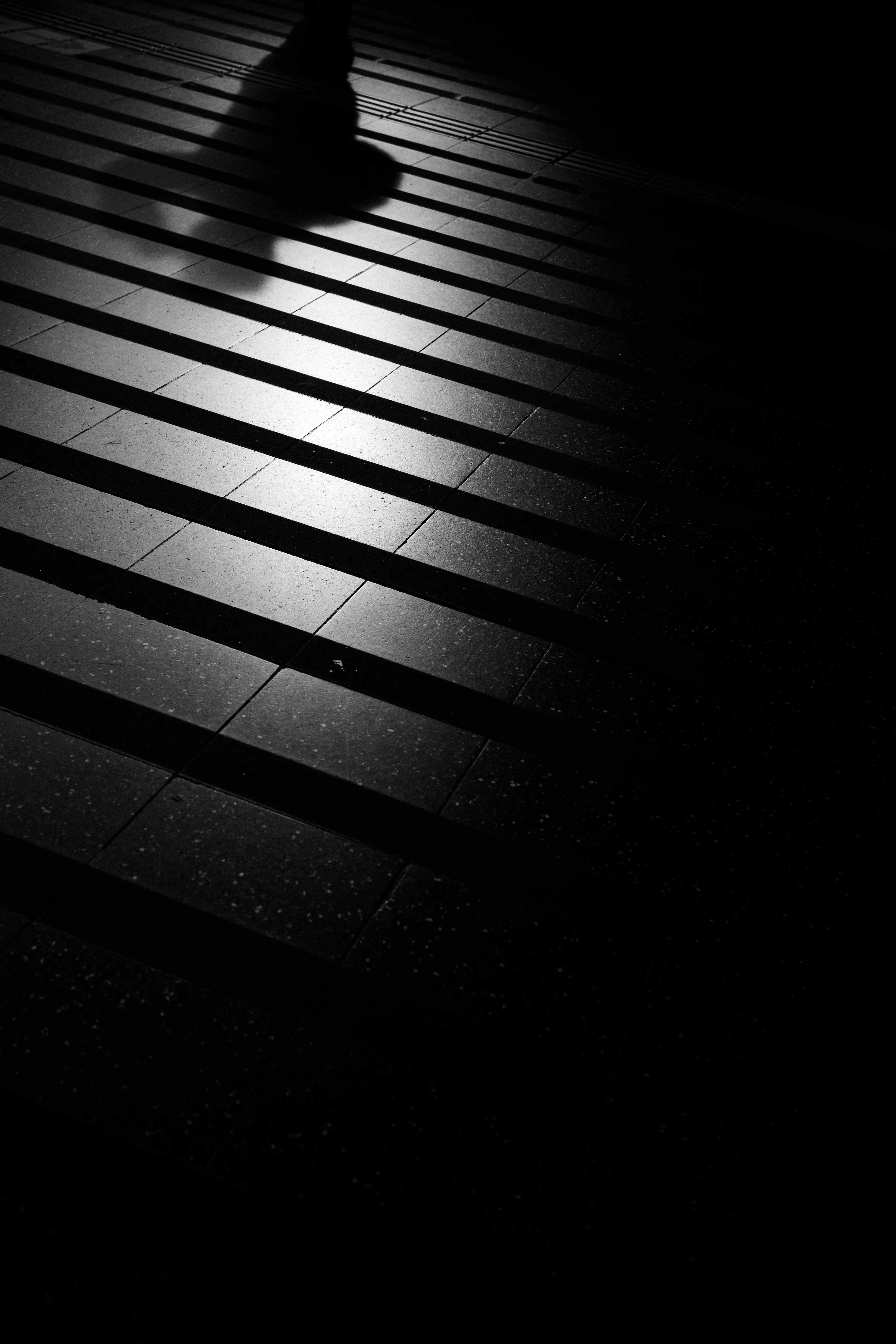 Silhouette of a pedestrian on striped pavement in low light