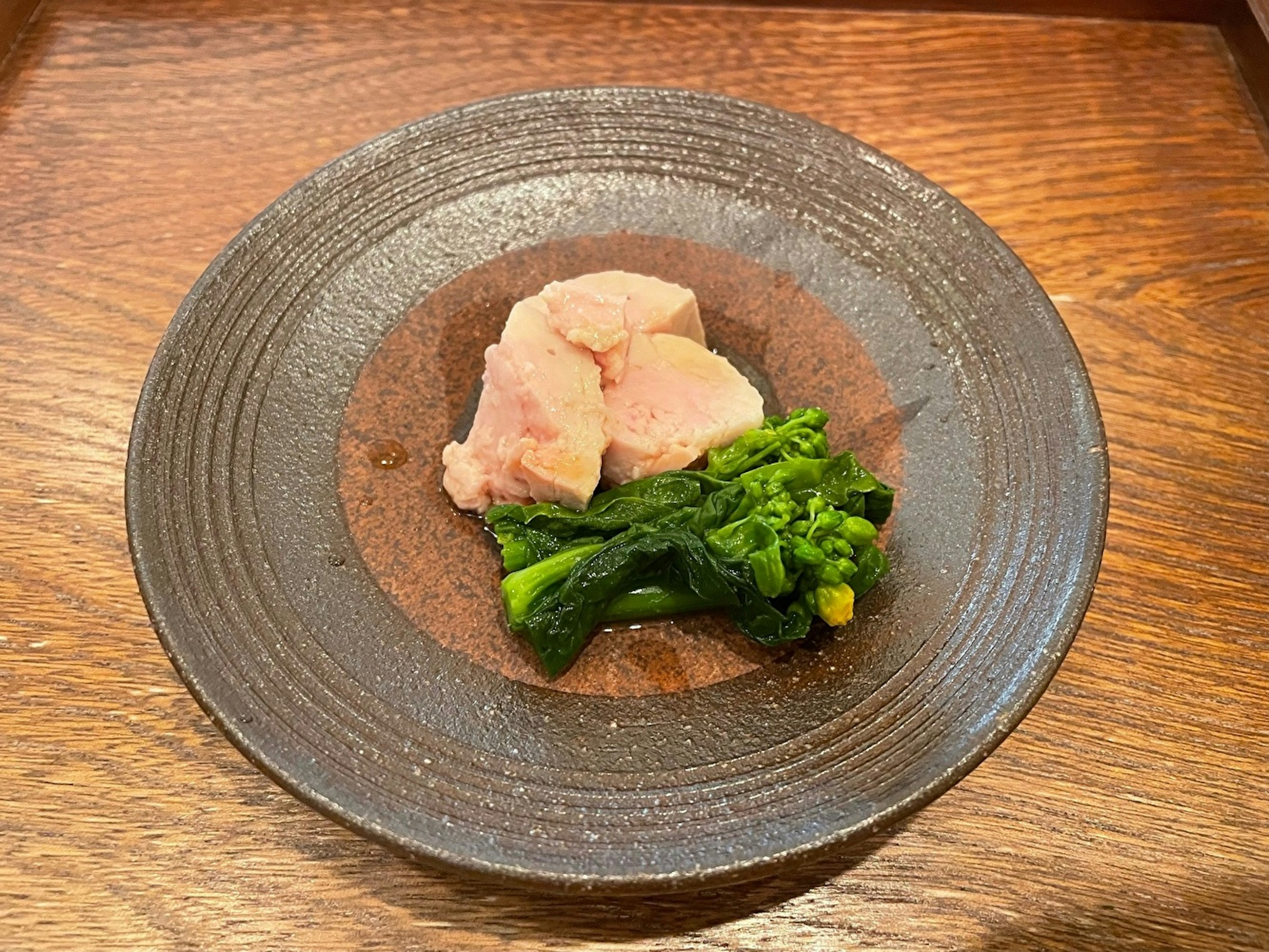 Chicken and green vegetables served on a beautiful black plate