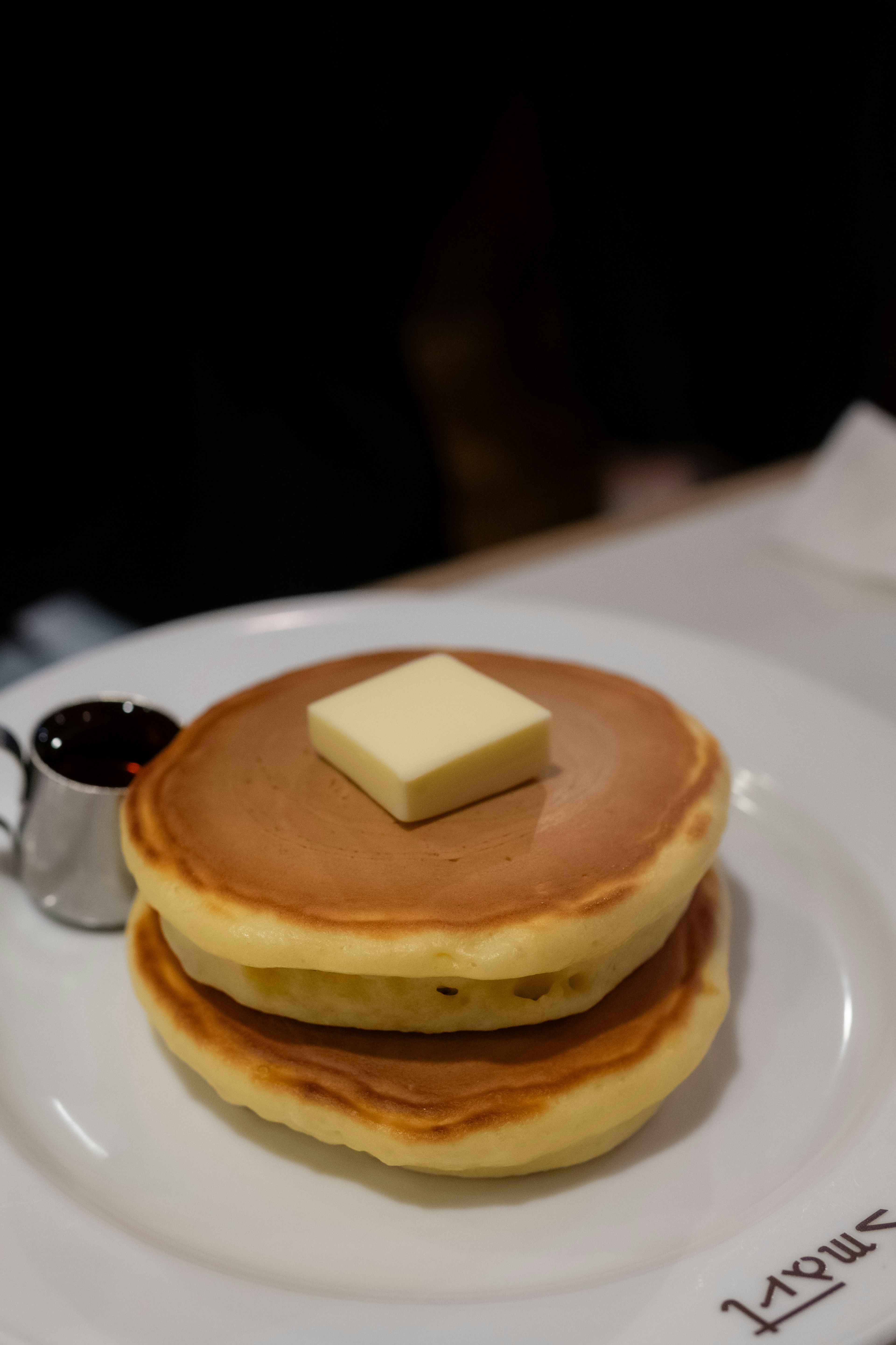 Zwei Pfannkuchen mit Butter und serviert mit Ahornsirup